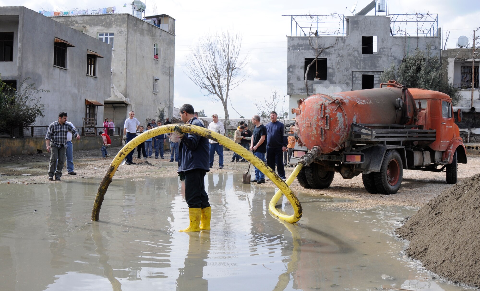 A local sewage company assists in the effort to renovate a local playground by pumping water off the lot for members of the 385th Air Expeditionary Group to begin building the park for local Turkish children Wednesday, Feb. 25, 2009, in Adana, Turkey. The members of the group are Air National Guardsmen based in Sioux City, Iowa and were here at Incirlik for temporary duty supporting operations for Central Command. (U.S. Air Force photo/Airman 1st Class Amber Russell)