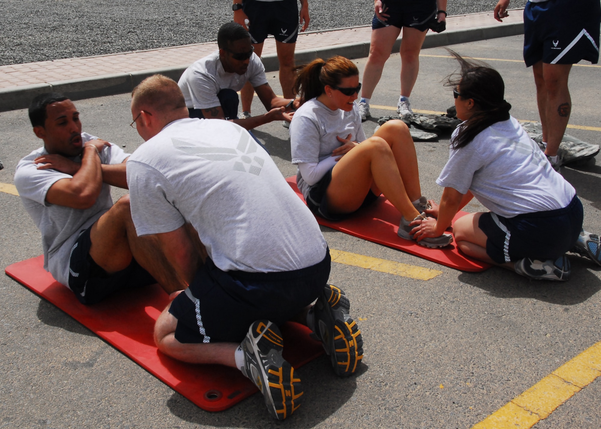 SOUTHWEST ASIA -- Airmen from the 386th Expeditionary Security Forces Squadron race to complete 30 sit-ups during the Fire Team Challenge at an air base in Southwest Asia, March 22. The time challenge included pull-ups, self-aid and buddy care, M-4 assembly, sit-ups, push-ups, litter carry and an Airman's Creed puzzle. (U.S. Air Force photo/ Senior Airman Courtney Richardson)