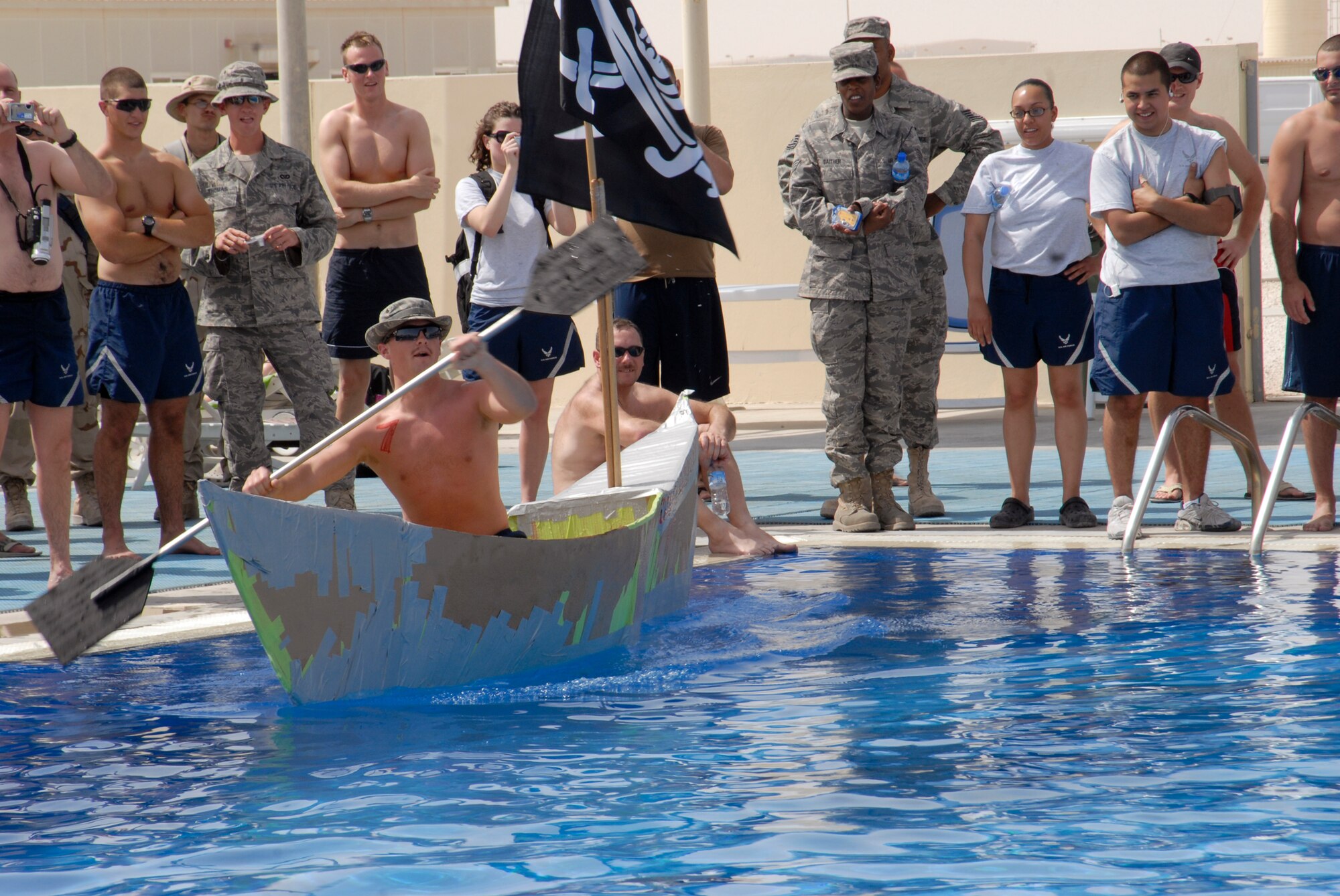 Personnel from all different military services participate in a build-your-own cardboard boat race in the Coalition Compound pool, Mar. 22, 2009, at an undisclosed location in Southwest Asia.  Services hosted the event for the 379th Expeditionary Force Support Squadron to provide a welcomed relief for servicemembers deployed in support of Operations Iraqi and Enduring Freedom and Combined Joint Task Force - Horn of Africa.  (U.S. Air Force photo/Senior Airman Andrew Satran/released)