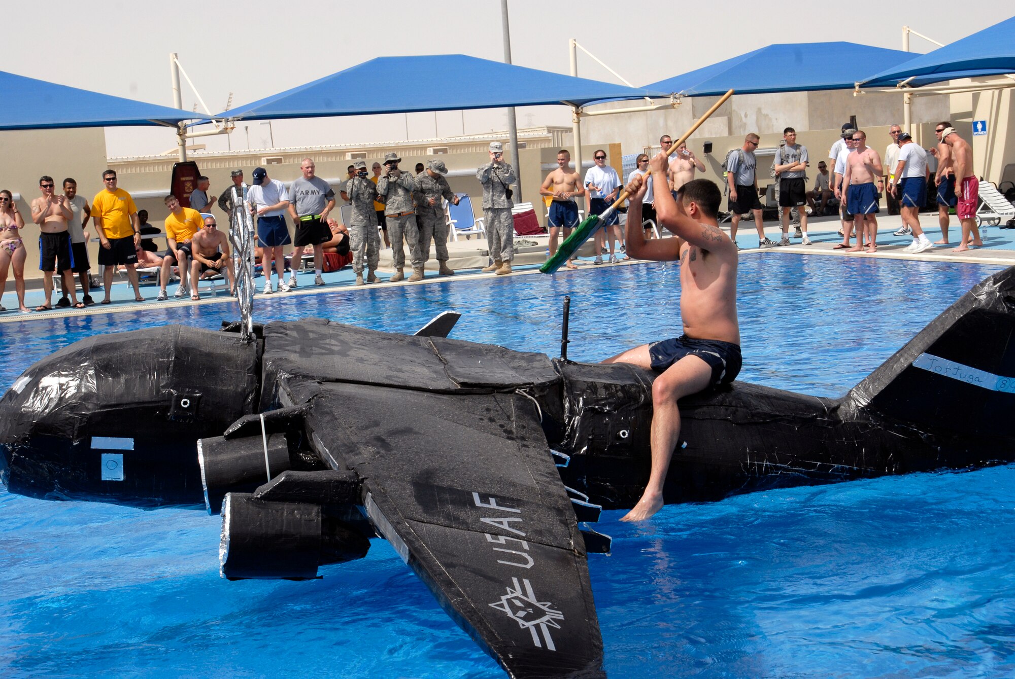 Personnel from all different military services participate in a build-your-own cardboard boat race in the Coalition Compound pool, Mar. 22, 2009, at an undisclosed location in Southwest Asia.  Services hosted the event for the 379th Expeditionary Force Support Squadron to provide a welcomed relief for servicemembers deployed in support of Operations Iraqi and Enduring Freedom and Combined Joint Task Force - Horn of Africa.  (U.S. Air Force photo/Senior Airman Andrew Satran/released)