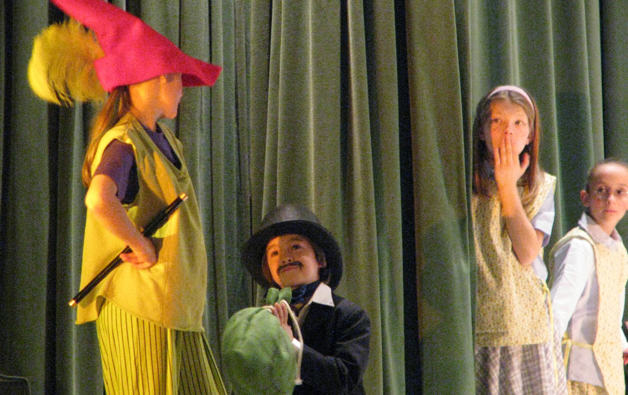 SPANGDAHLEM AIR BASE, Germany – Sara Miller, playing the role of Piper, receives payment from the mayor, played by Koby Kirk, as Sierra Locker and Carolyn Pindel look on. The youth are all students at the Spangdahlem Elementary School in Mrs. Harvin's Drama Club. The club preformed "Rats! The Tale of the Pied Piper" March 18-19, 2009. (Photo by Kristin Bleha)