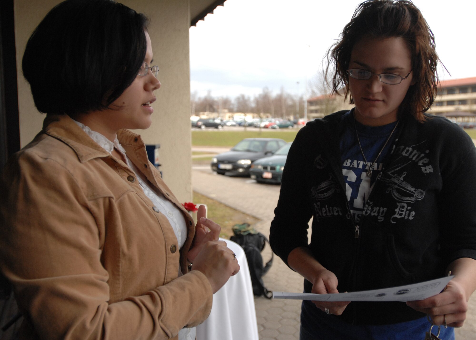SPANGDAHLEM AIR BASE, Germany -- Senior Airman Leonor Carlos, 52nd Medical Operations Squadron, promotes the Prisoner of War coins to Airman Mara Savo, 52nd Medical Support Squadron, March 13, 2009. Airman Carlos is a member of the Air Force Sergeants Association that hosted a fundraiser to raise money for POW awareness.  (U.S. Air Force photo by Senior Airman Jenifer H. Calhoun)