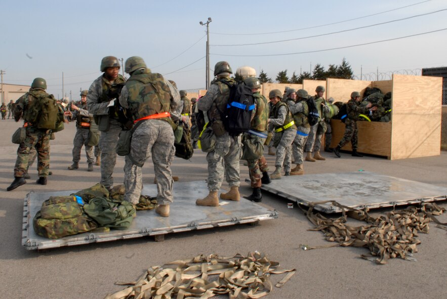 Airmen from the 8th Fighter Wing download cargo pallets during Wolf War day at Kunsan Air Base, Republic of Korea, March 23, 2009. The 8th Fighter Wing Airmen participate in Wolf War day practicing their war time capabilities in preparation for the Peninsula Wide Operational Readiness Exercise and Inspection. (US Air Force photo By: Senior Airman Angela Ruiz) 