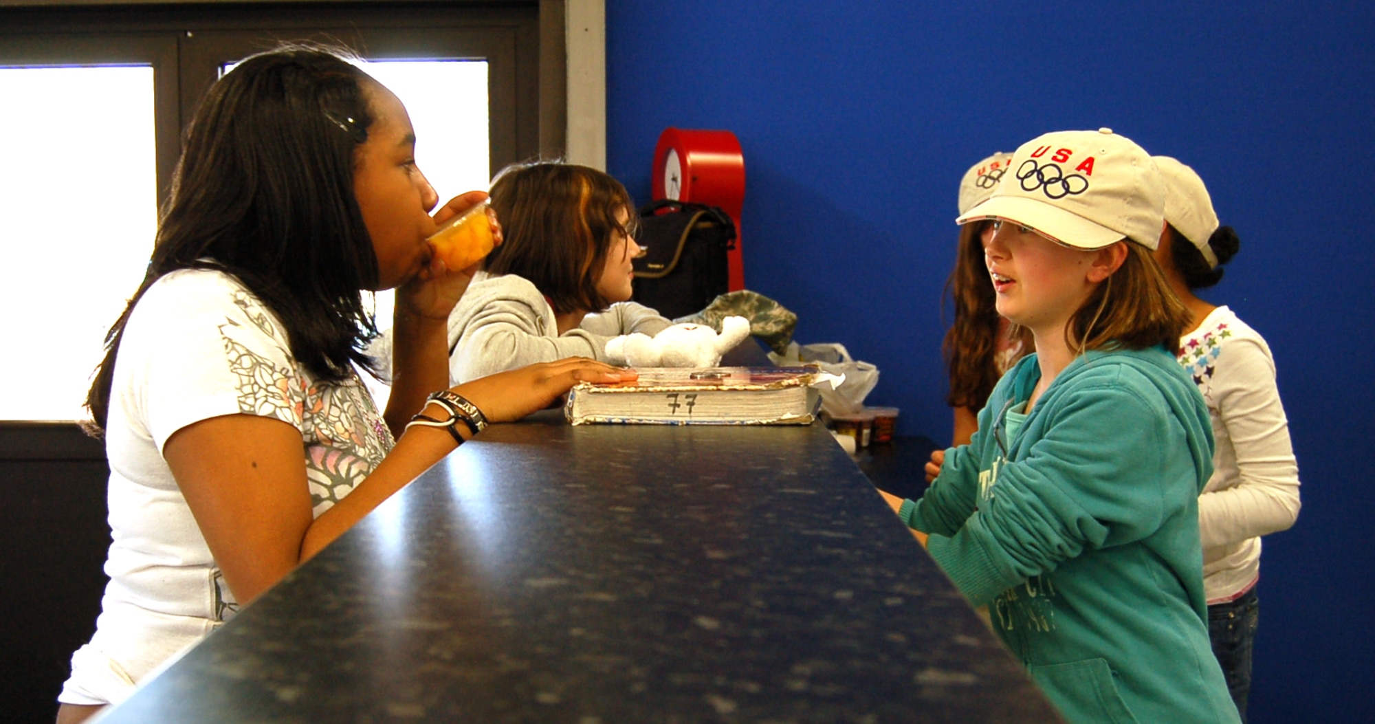 SPANGDAHLEM AIR BASE, Germany – Kayla Peel, (in blue jacket) Spangdahlem Middle School student, serves customers at the snack bar in the newly renovated Spangdahlem Youth Program Building March 18, 2009. The snack bar is run by members of the Torch Club. Kayla is the daughter of Master Sgt. Shannon Burrier, 52nd Fighter Wing, and Senior Master Sgt. Danny Morris, 52nd Operations Support Squadron. (U.S. Air Force photo by Staff Sgt. Tammie Moore)