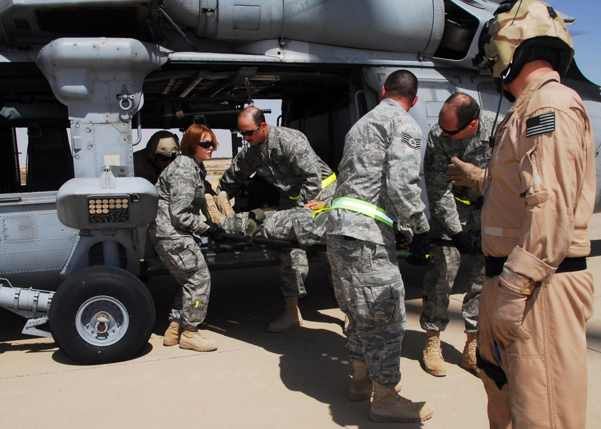 SOUTHWEST ASIA -- Airmen from the 386th Expeditionary Medical Group unload a simulated patient from a Navy medevac helicopter during Litter Management System Training at an air base in Southwest Asia, March 20. The LMS training better prepares the 386th EMDG and the 2515th Naval Air Ambulance, from an Army base in Southwest Asia, to complete the mission more efficiently while keeping safety for themselves and the patients in mind. (U.S. Air Force photo/ Senior Airman Courtney Richardson)