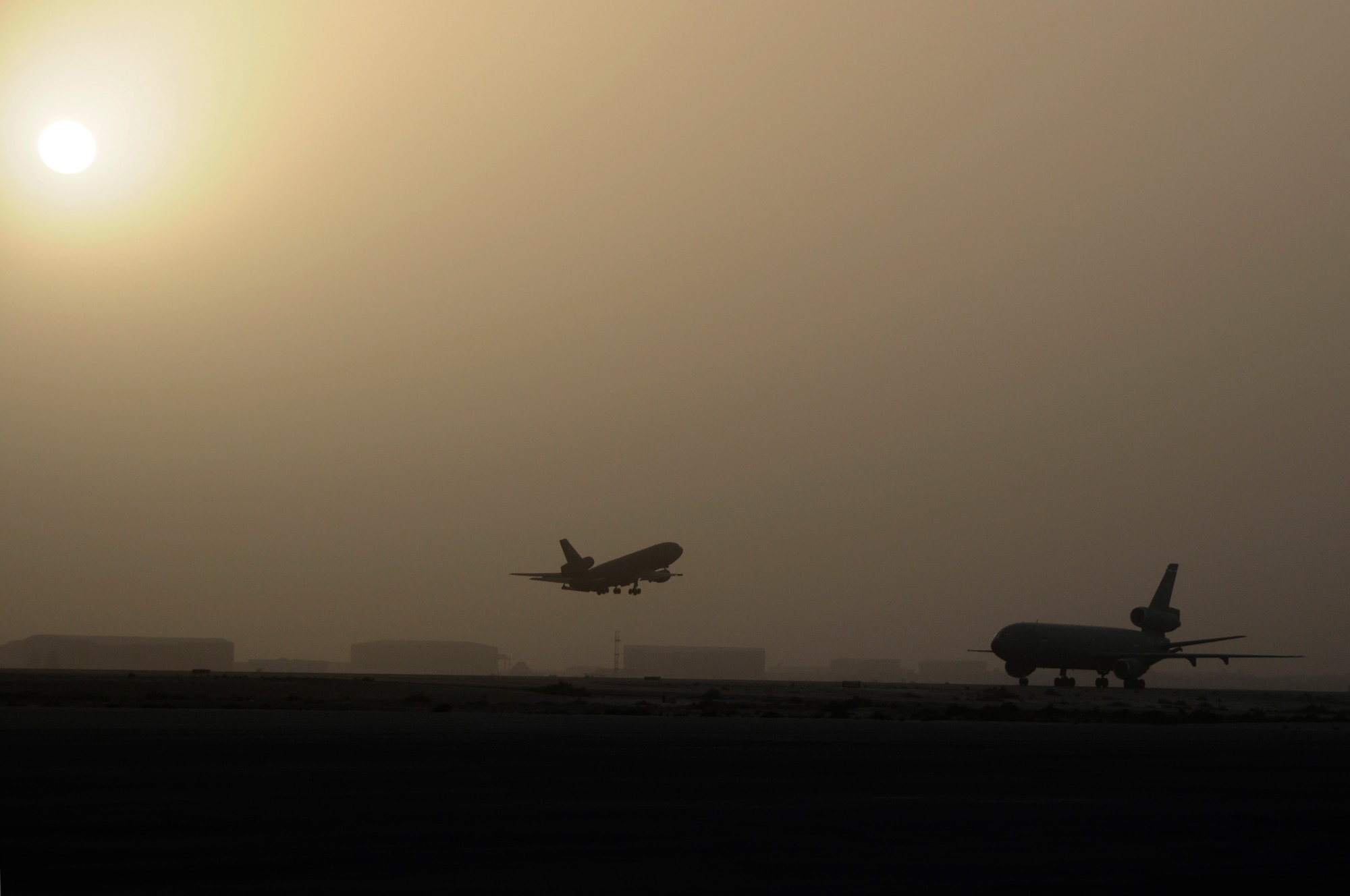 SOUTHWEST ASIA - A KC-10 Extender taxis in as another takes off from the flightline of the 380th Air Expeditionary Wing, Mar 23. The 380th AEW flies refueling and reconnaissance missions 24/7 in support of Operations Iraqi and Enduring Freedom and Joint Task Force Horn of Africa.  (U.S. Air Force photo by Senior Airman Brian J. Ellis) (Released)