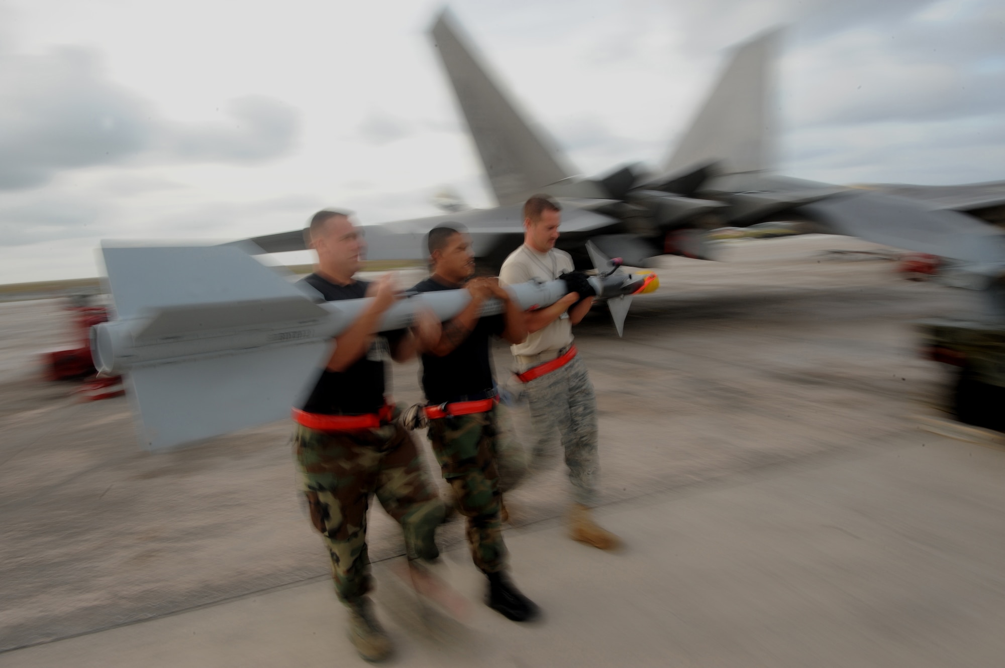 (L-R) Staff Sgt. Luke Vetter, Senior Airman Matias Castro and Staff Sgt. Steve Nehls load an AIM-9 (CATM) captive air training missile March 19 at Andersen Air Force Base, Guam during exercise Jungle Shield. The surveillance and control of U.S. airspace in the Pacific Commands Area of Responsibility remains a prime mission focus for the men and women of the 13th Air Force. The Raptors are deployed from Elmendorf Air Force Base, Alaska to Guam as the 90th Expeditionary Fighter Squadron for three months as the Pacific's Theater Security Package. (U.S. Air Force photo/ Master Sgt. Kevin J. Gruenwald) released      
