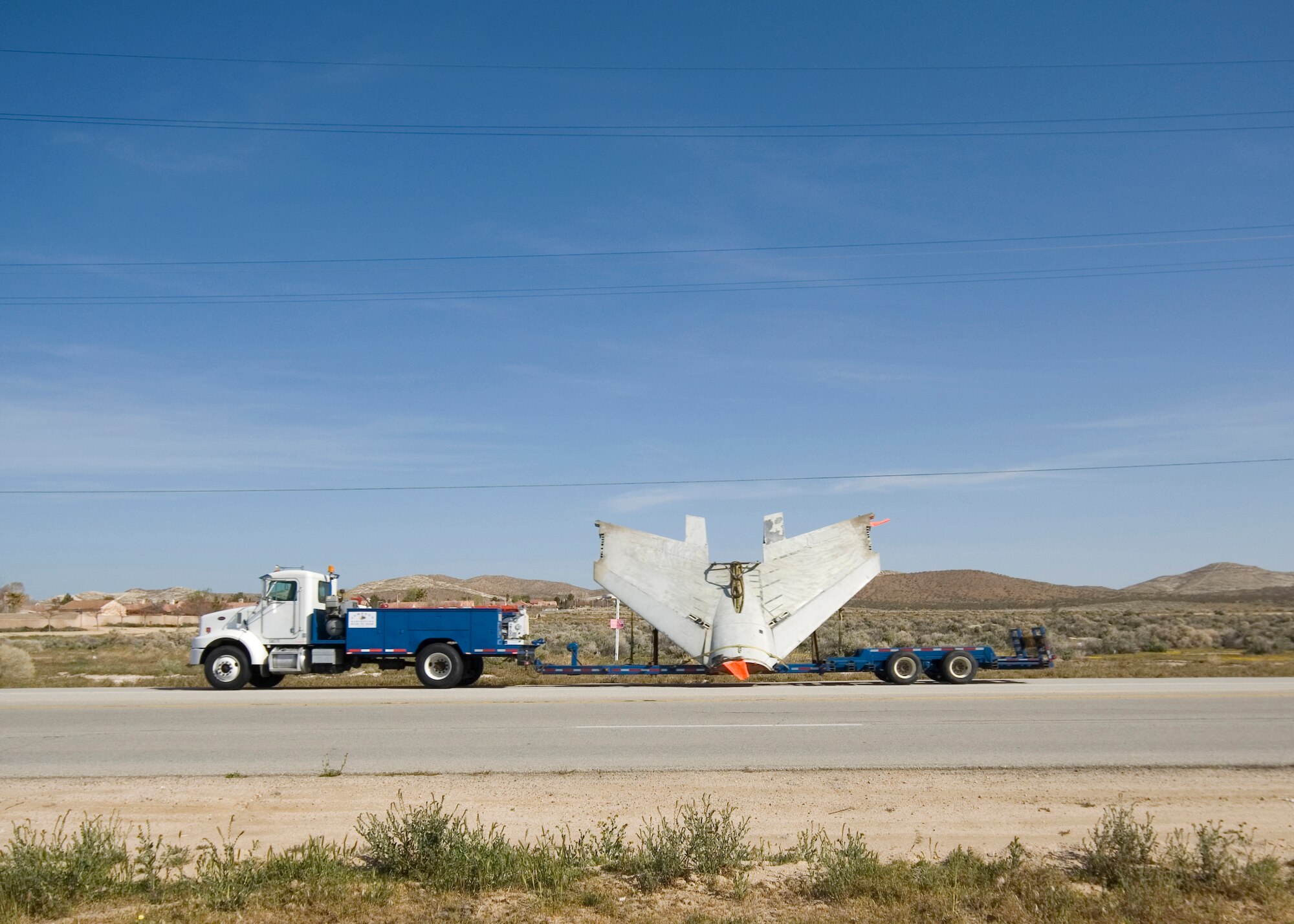 An RF-8's wing section exits the base on the back of a truck as it makes its way to Castle Air Museum. The aircraft is now going to be on display at Castle Air Museum. (Air Force photo by Mike Cassidy)