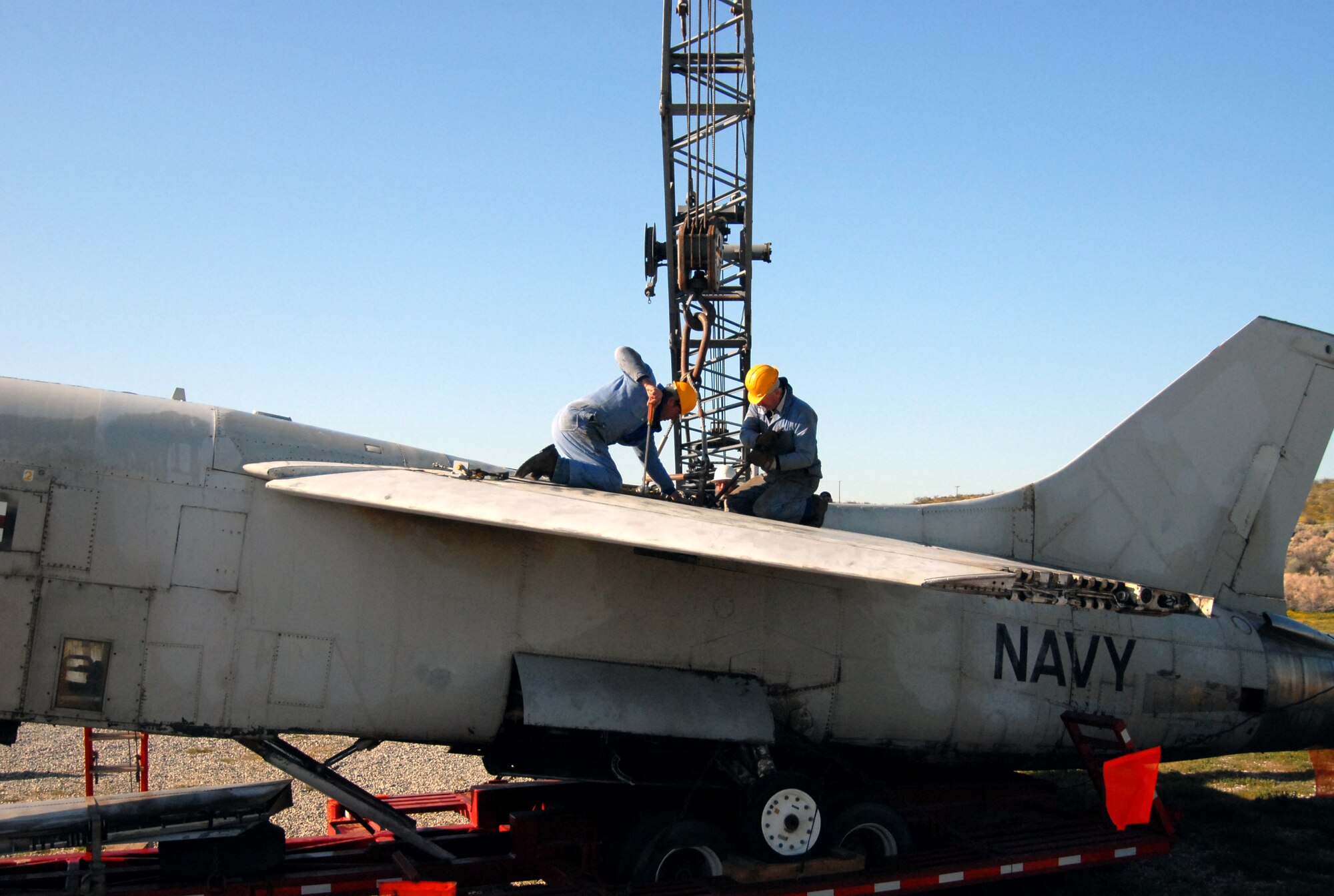 Pat Jameson and Mike Jameson detach the RF-8's wing section behind the Air Force Flight Test Center Museum March 24. The aircraft was dismantled prior to being transported to Castle Air Museum in order to meet California Transportation standards. (Air Force photo by Airman 1st Class William O'Brien)