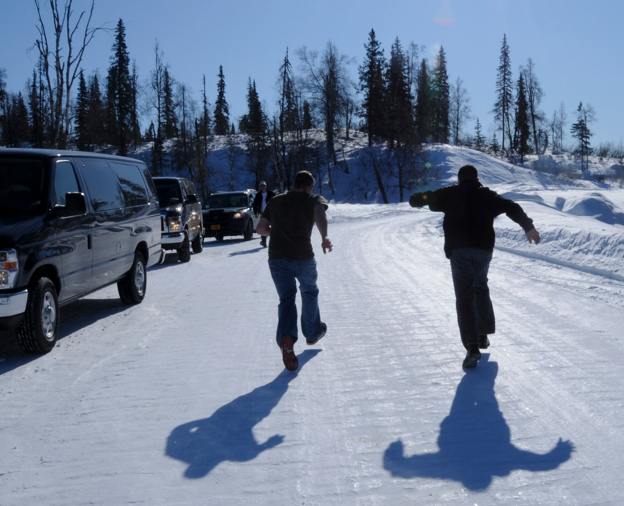 Airman 1st Class Tyler Barresi, 354th Logistics Readiness Squadron, and Senior Airman Philip Sonderman, 354th Logistics Readiness Squadron, run to slide uphill March 20, 2009, Denali National Park and Preserve, Alaska. The group stopped here to stretch and view Mount McKinley, the highest mountain peak in North America, at a height of approximately 20,320 feet, located in Denali National Park.  (U.S. Air Force photo/Airman 1st Class Laura Max)