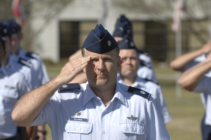 Lt. Col. Richard Williamson, 17th Airlift Squadron commander, salutes the flag during the retreat ceremony here March 20. Starting April 15, Charleston AFB will begin playing "To the Colors" during reveille. (U.S. Air Force Photo/James Bowman)