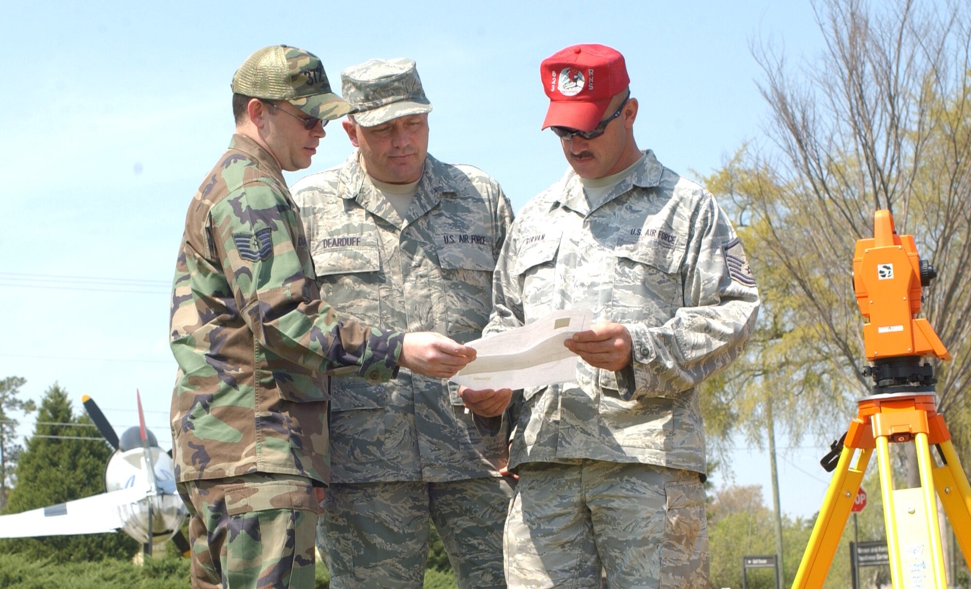 Shaw Air Force Base, S.C. -- Tech. Sgt. Kevin Darrow, 372nd Training Recruiting Squadron Detachment 2 flight chief; Chief Master Sgt. Scott Dearduff, 9th Air Force and U.S. Air Forces Central Command Chief Master Sergeant; and Master Sgt. Jerry Girvan, 823 Red Horse Squadron project manager, review plans for the 9 AF and USAFCENT Airmen’s Memorial at the memorial’s future site, the 9 AF and USAFCENT Headquarters parade grounds. (photo by Staff Sgt. Amanda Savannah)