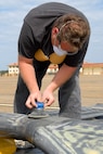 In preparation for a new paint job, Jonnie Wilson of Man-Power Flight-line Services sands part of a rotor blade for the CH-53 helicopter that will soon become a static display at Maxwell. The aircraft was presented to Air University and Maxwell-Gunter by the Air Force Special Operations Command and will be placed in front of the Chaplain’s School at the corner of East Ash and Twining streets in Maxwell’s Air Park. (Air Force photo by Jamie Pitcher)