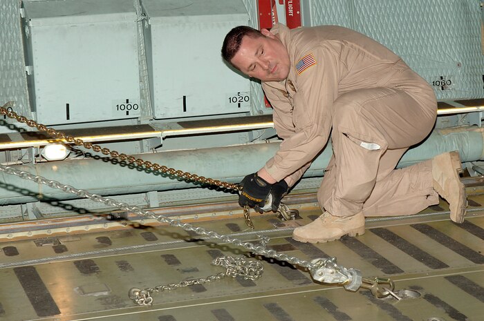 Senior Master Sgt. Mark Snyder secures a Mine-Resistant, Ambush-Protected egress simulator onto a C-5 here March 20. The simulators are used to train deployed military members how to egress out of a MRAP that has overturned. Sergeant Snyder is with the 167th Airlift Wing, Air National Guard, W. Va. (U.S. Air Force photo/Staff Sgt. Marie Cassetty)(RELEASED)