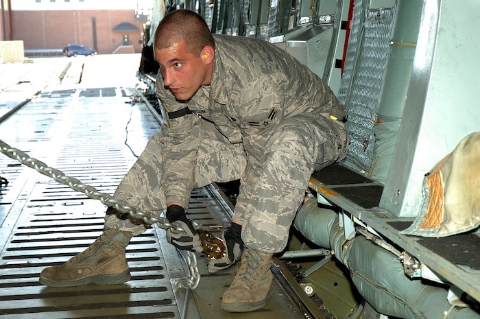 Airman 1st Class David Marcum secures a Mine-Resistant, Ambush-Protected egress simulator onto a C-5 here March 20. The simulators are used to train deployed military members how to egress out of a MRAP that has overturned. Airman Marcum is with the 437th Aerial Port Squadron. (U.S. Air Force photo/Staff Sgt. Marie Cassetty)(RELEASED)