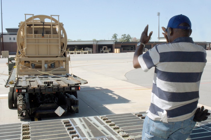 Ricky Gathers directs a 60k loader into position to load a Mine-Resistant, Ambush-Protected egress simulator here March 20. The simulators are used to train deployed military members how to egress out of a MRAP that has overturned. Mr. Gathers is a motor vehicle operator with the 437th Aerial Port Squadron. (U.S. Air Force photo/Staff Sgt. Marie Cassetty)(RELEASED)