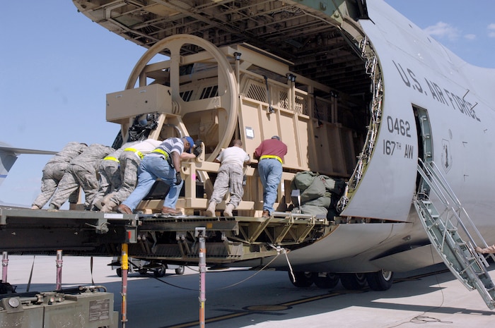 Airmen with the 437th Aerial Port Squadron push a Mine-Resistant, Ambush-Protected egress simulator onto a C-5 here March 20. The simulators are used to train deployed military members how to egress out of a MRAP that has overturned. (U.S. Air Force photo/Staff Sgt. Marie Cassetty)(RELEASED)