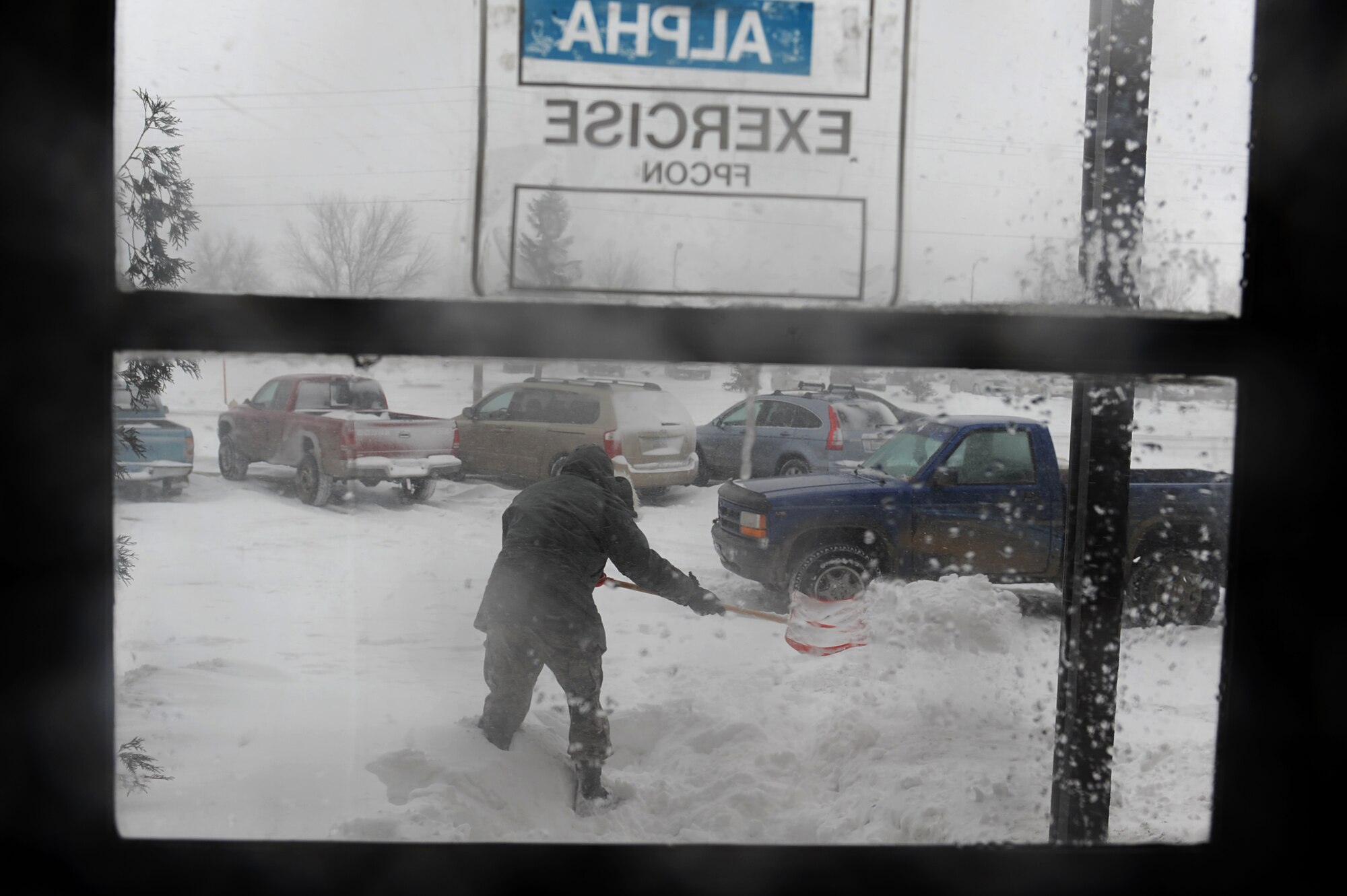 MINOT AIR FORCE BASE, N.D. – Senior Airman Joe Rivera, a photographer from Minot AFB public affairs, shovels the side entrance to the 5th Bomb Wing Headquarters building during a blizzard hereMarch 24. Airmen from the 5th Bomb Wing and 91st Missile Wing were released early due to the forecasted hazardous weather conditions. (U.S. Air Force photo by Senior Airman Kelly Timney)