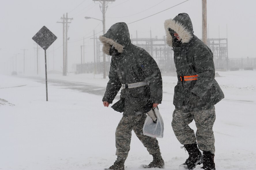 MINOT AIR FORCE BASE, N.D. – Senior Airman Osha Parker, a refueling equipment operator, and Senior Airman Louis Solsbury, a fuels distribution journeyman, both from the 5th Logistics Readiness Squadron, cross Bomber Boulevard as they head to work during a blizzard here March 24.  Airmen from the 5th Bomb Wing and 91st Missile Wing were released early due to the forecasted hazardous weather conditions. 2009 was a year that brought progress and a renewed emphasis on safe, secure and reliable nuclear operations. The 91st Missile Wing transitioned to Air Force Global Strike Command with the 5th Bomb Wing scheduled to follow suit in 2010. (U.S. Air Force photo by Senior Airman Kelly Timney)
