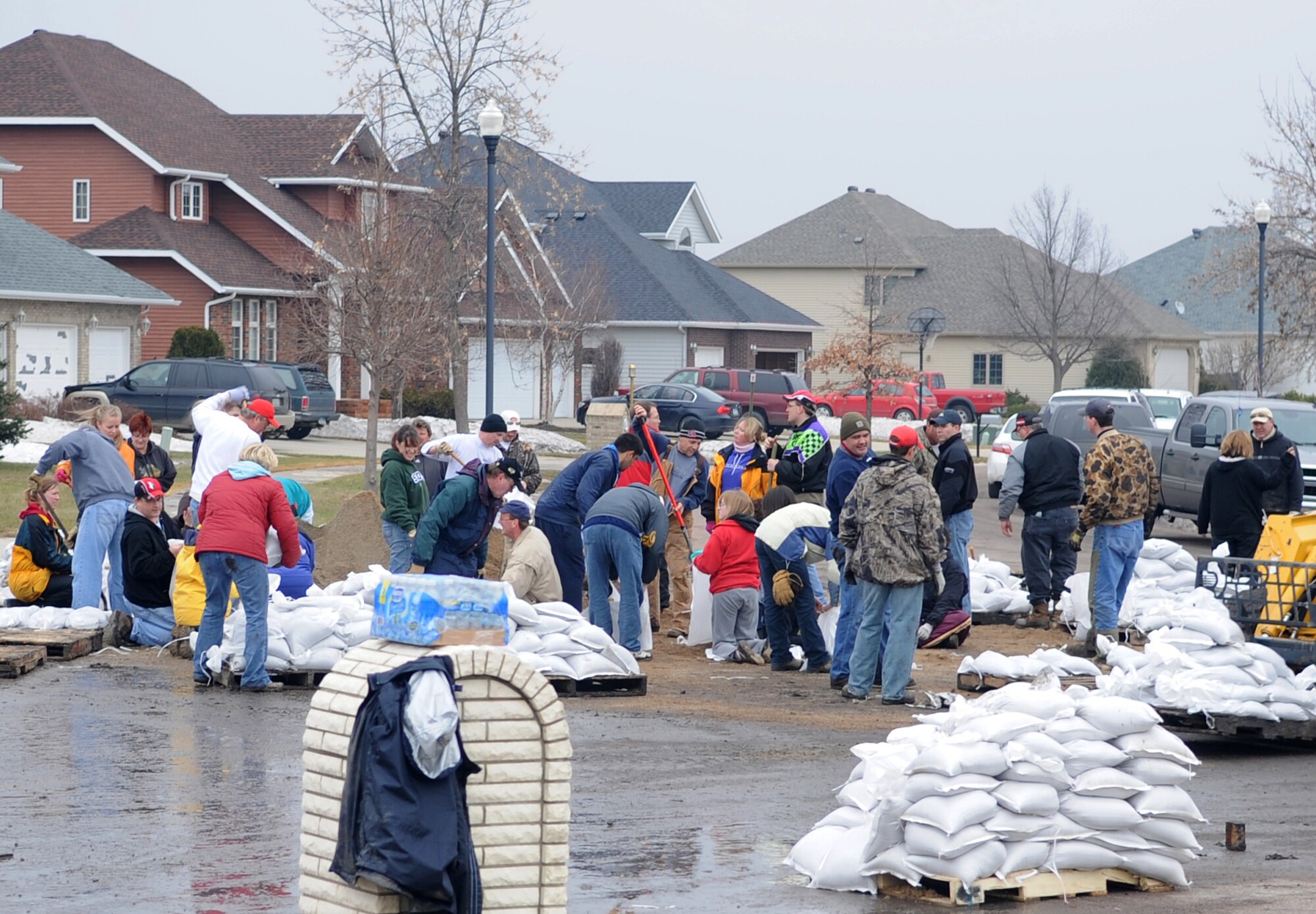 Volunteers and neighbors gather around to fill and move sandbags in a Fargo, N.D., neighborhood in danger of flooding. More than 100 Airmen have volunteered to assist in flood protection efforts to date. (U.S. Air Force photo/Tech. Sgt. Amanda Callahan)