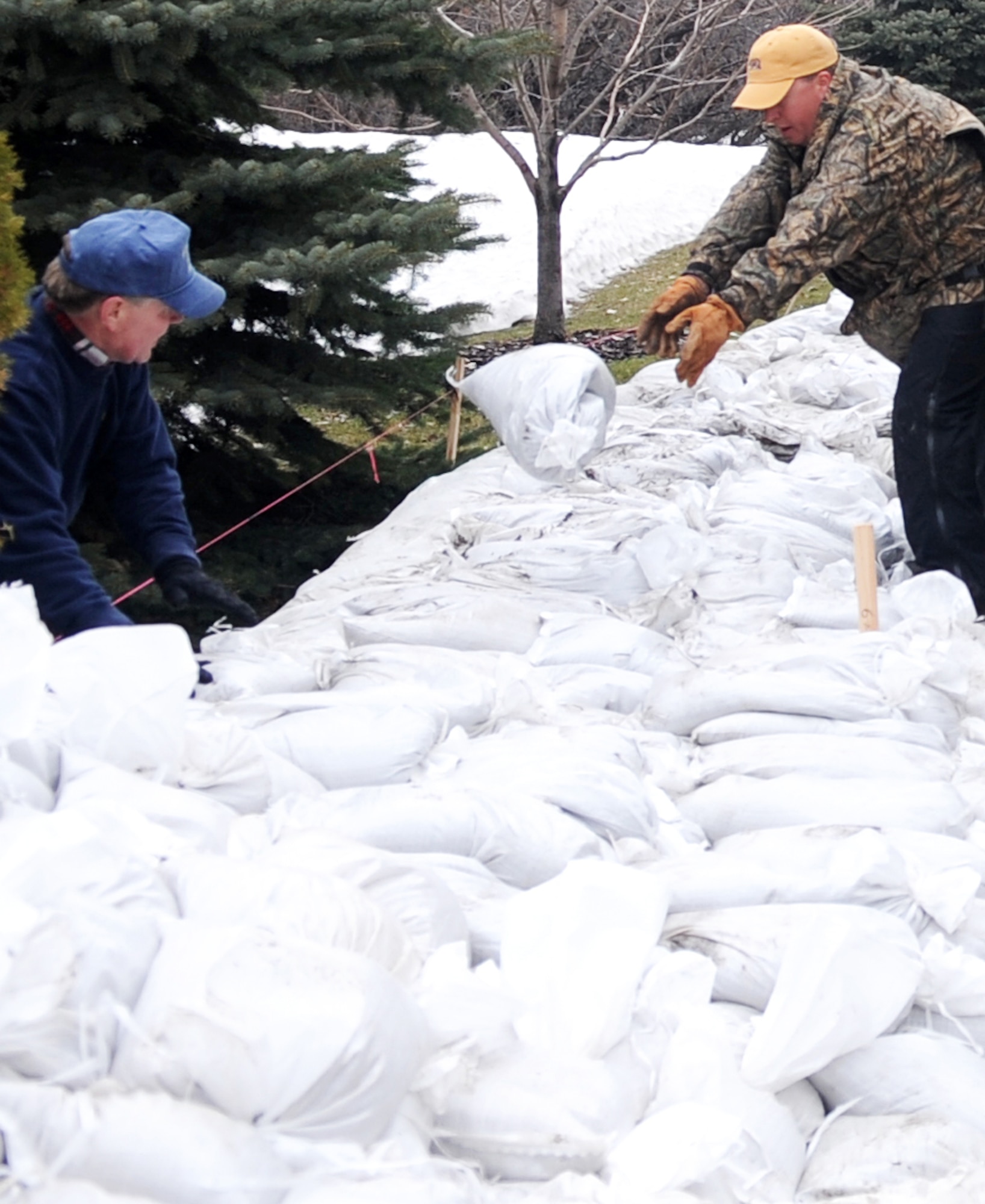 Volunteers and neighbors work together to protect homes from rising flood waters in a Fargo, N.D., neighborhood. Many Grand Forks Air Force Base, N.D., Airmen have volunteered throughout the region to support flood protection efforts. (U.S. Air Force photo/Tech. Sgt. Amanda Callahan)