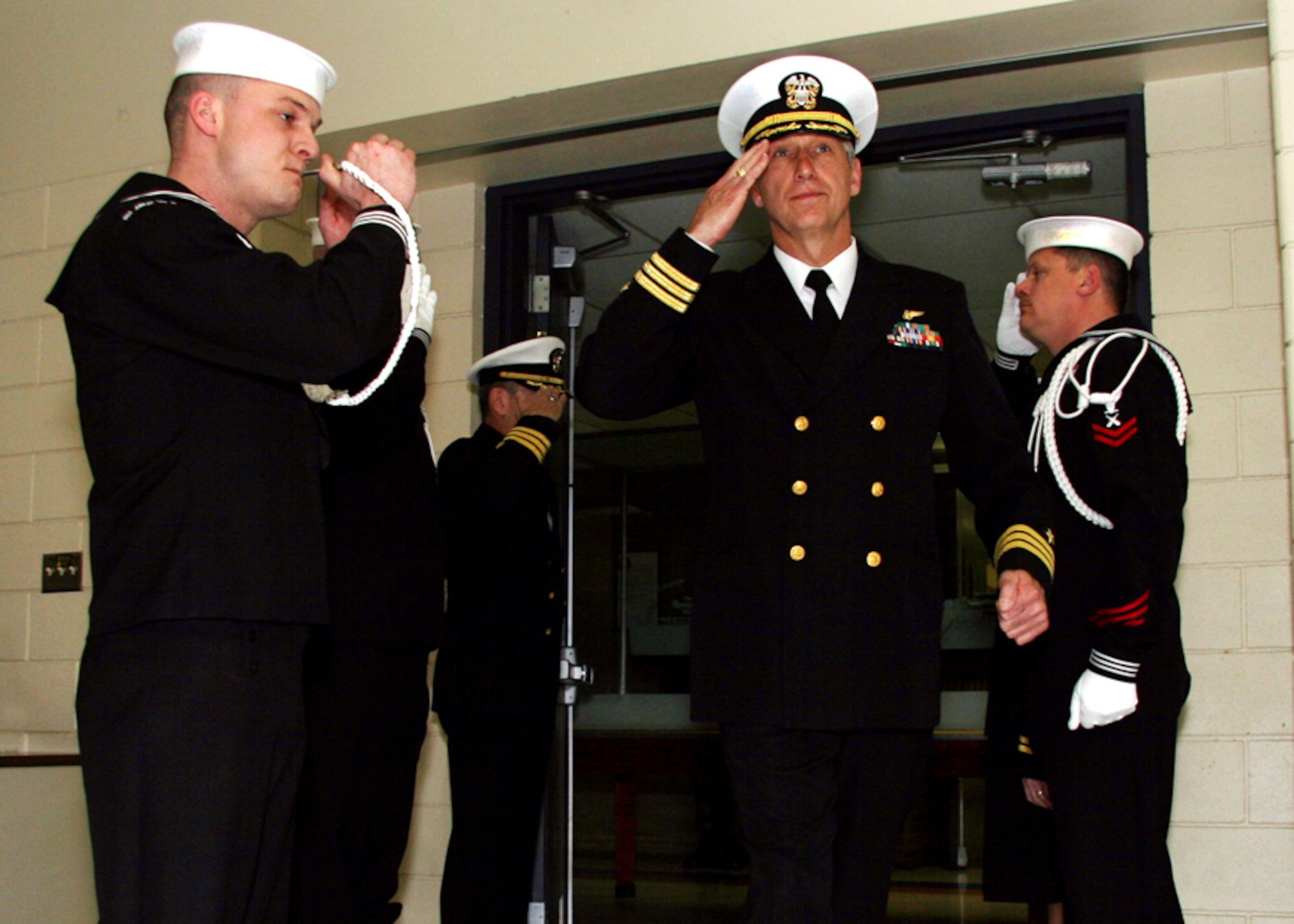 WICHITA, Kan. -- Navy Cmdr. Michael Boettcher salutes as he is piped aboard by Boatswain's Mate 3rd Class Robert Cooke during his retirement, March 14, after 34 years of distinguished military service. Observing naval tradition, the ceremony was held at the Naval Operational Support Center in Wichita. Commander Boettcher began his military career serving four years enlisted in the Air Force. After he earned a bachelor of science in accounting, he was accepted in the Navy flight program. He earned his wings of gold in 1982 and has logged 4,500 hours flying helicopters and fixed wing aircraft. (U.S. Navy photo by Mass Communication Specialist 2nd Class Ron Trevino)