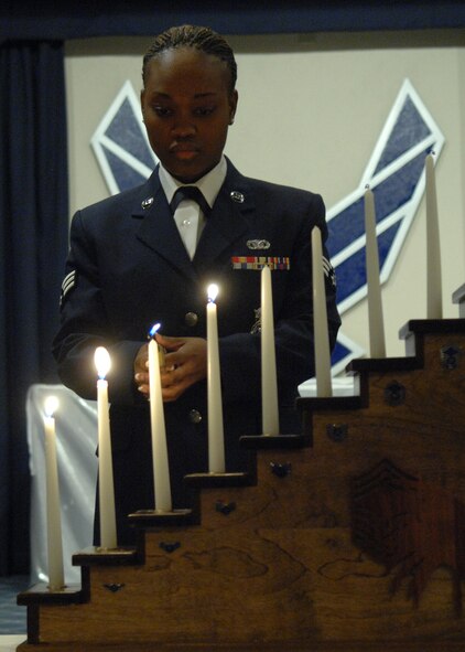 Senior Airman Miriam Lucas, lights the enlisted candles during the Chief Recongition Ceremony March 21 at  Holloman Air Force Base, N.M. Airman is Lucas is assigned to the Security Forces Squadron, 49th Fighter Wing. (U.S. Air Force photo/SSgt Anthony Nelson Jr)