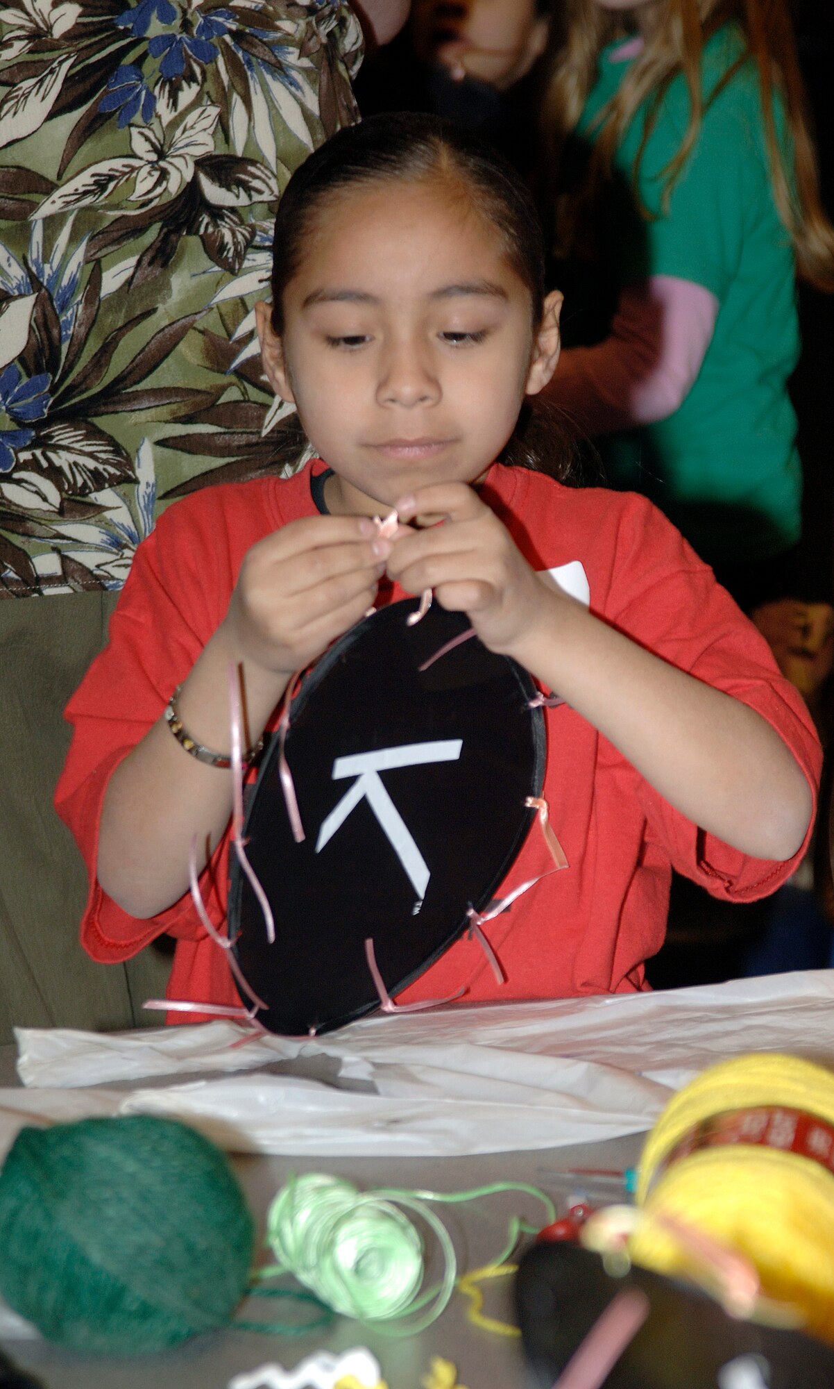 MCCONNELL AIR FORCE BASE, Kan. -- Selena Mejia, 8, daughter of Senior Airman Anthony Mejia, 22nd Air Refueling Wing, makes a fan during a session for the School Age Program at the Robert J. Dole Community Center, March 19. The program provides a place for active-duty dependents to stay while public schools are on holiday and during after school hours. (Photo by Senior Airman Laura Suttles)