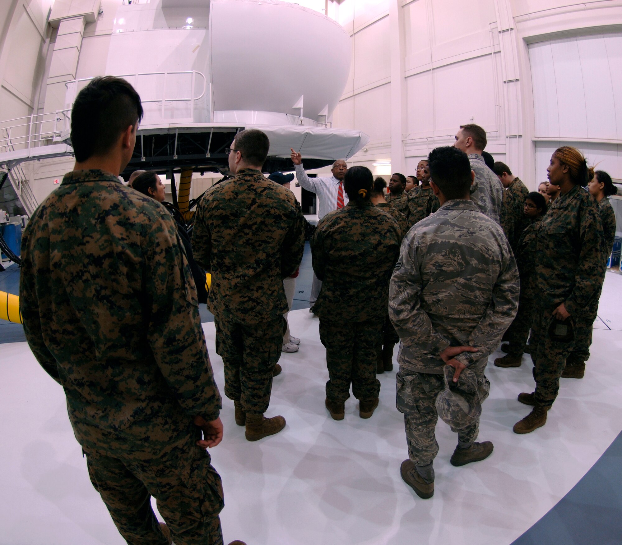 MCCONNELL AIR FORCE BASE, Kan. -- Rumsey Helms, 22nd Operations Group, provides a group of Hickman Mills High School Marine junior reserve officer training corps students with a tour of a KC-135 simulator at McConnell, March 19. The simulator provides pilots with extensive training for all take-off, landing procedures and weather conditions. (Photo by Senior Airman Laura Suttles)