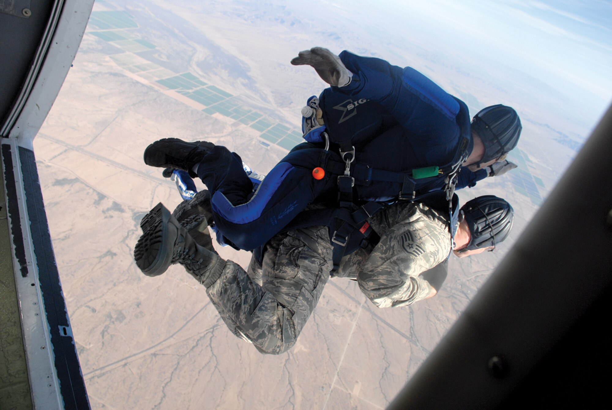 Staff Sgt. Ian Dean, 56th Fighter Wing photojournalist, jumps from a UV-18 aircraft in tandem with Maj. Michael Jacobson, 98th Flying Training Squadron.(U.S. Air Force photo/ Airman 1st Class Tracie Forte)