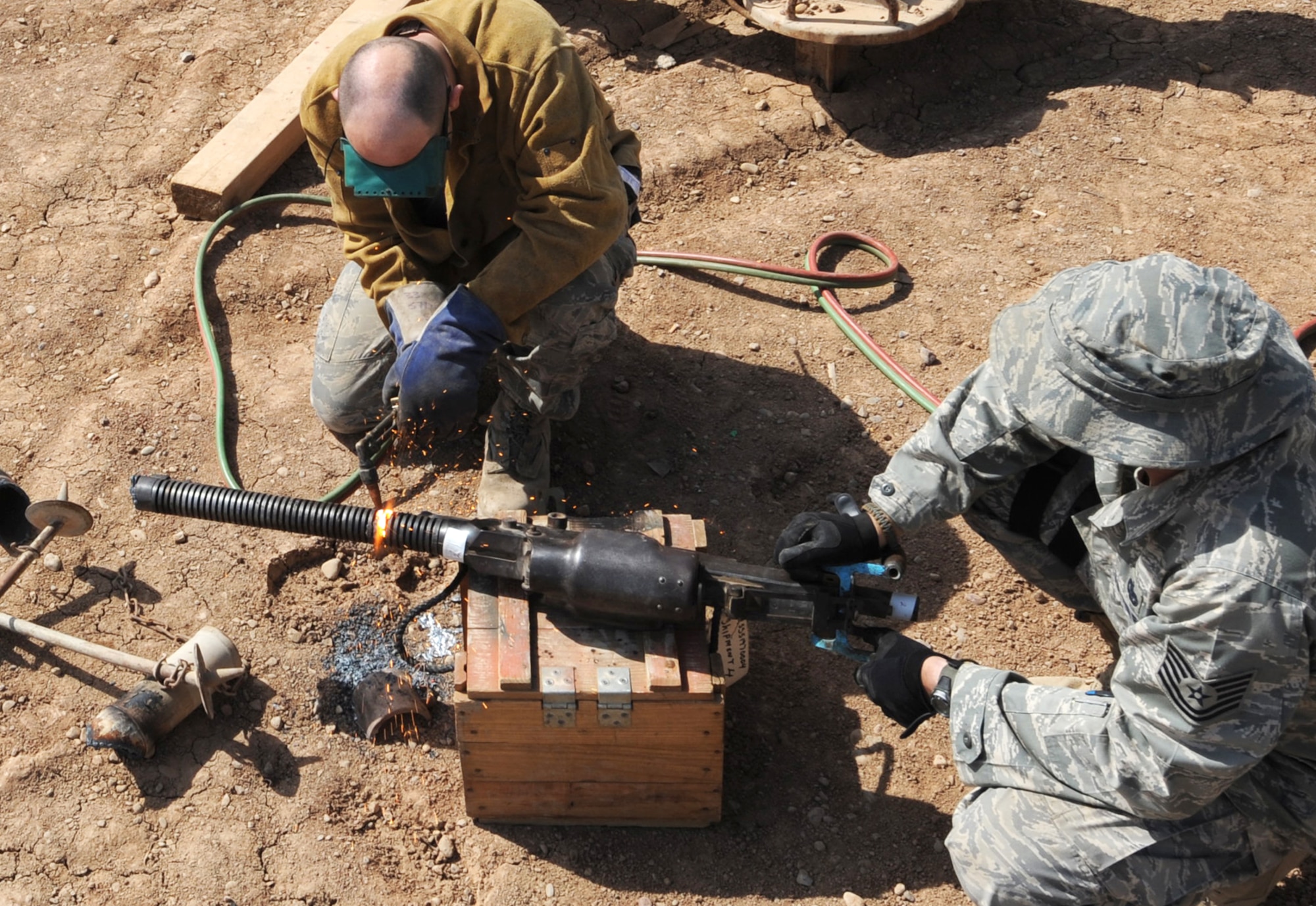 Tech. Sgt. Gregg Fleming holds a weapon steady as Tech. Sgt. Roy Hurd uses an oxy-acetylene torch to cut it at Joint Base Balad, Iraq, March 18. Enemy weapons were turned in by units and are being destroyed so they cannot be used against coalition forces and Iraqis. Sergeant Hurd is a 332nd Expeditionary Civil Engineer Squadron structural journeyman. Sergeant Fleming is the 332nd Expeditionary Security Forces Squadron assistant NCO in charge of combat arms training, maintenance and armory. (U.S. Air Force photo/Senior Airman Elizabeth Rissmiller)