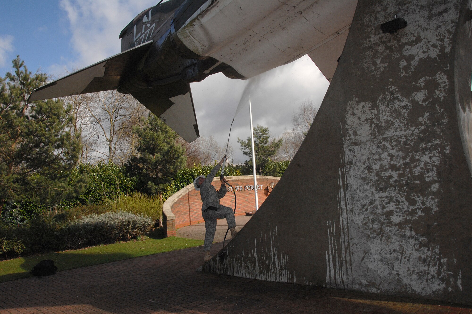 Senior Airman Kyle Cooper, 48th Fighter Wing Civil Engineer Squadron uses a pressure washer to clean debris off an aircraft at Memorial Park here March 25. The base took one day to perform a massive cleaning of the entire base and its facilities. (U.S. Air Force photo by Tech. Sgt. Christopher A. Campbell)
