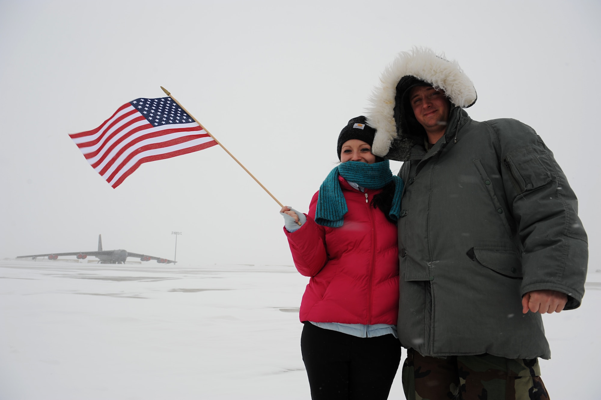 MINOT AIR FORCE BASE, N.D. -- Senior Airman Wesley Wright, Minot AFB public affairs staff writer, and his wife Jessica, pose for a picture on the flightline following his re-enlistment ceremony during a blizzard here March 24. Airman Wright wanted to create a memorable first re-enlistment by standing in front of a B-52H Stratofortress in Minot AFB’s infamous winter weather for before he and his wife move to their next base in Lakenheath, England this fall. (U.S. Air Force photo by Senior Airman Kelly Timney)