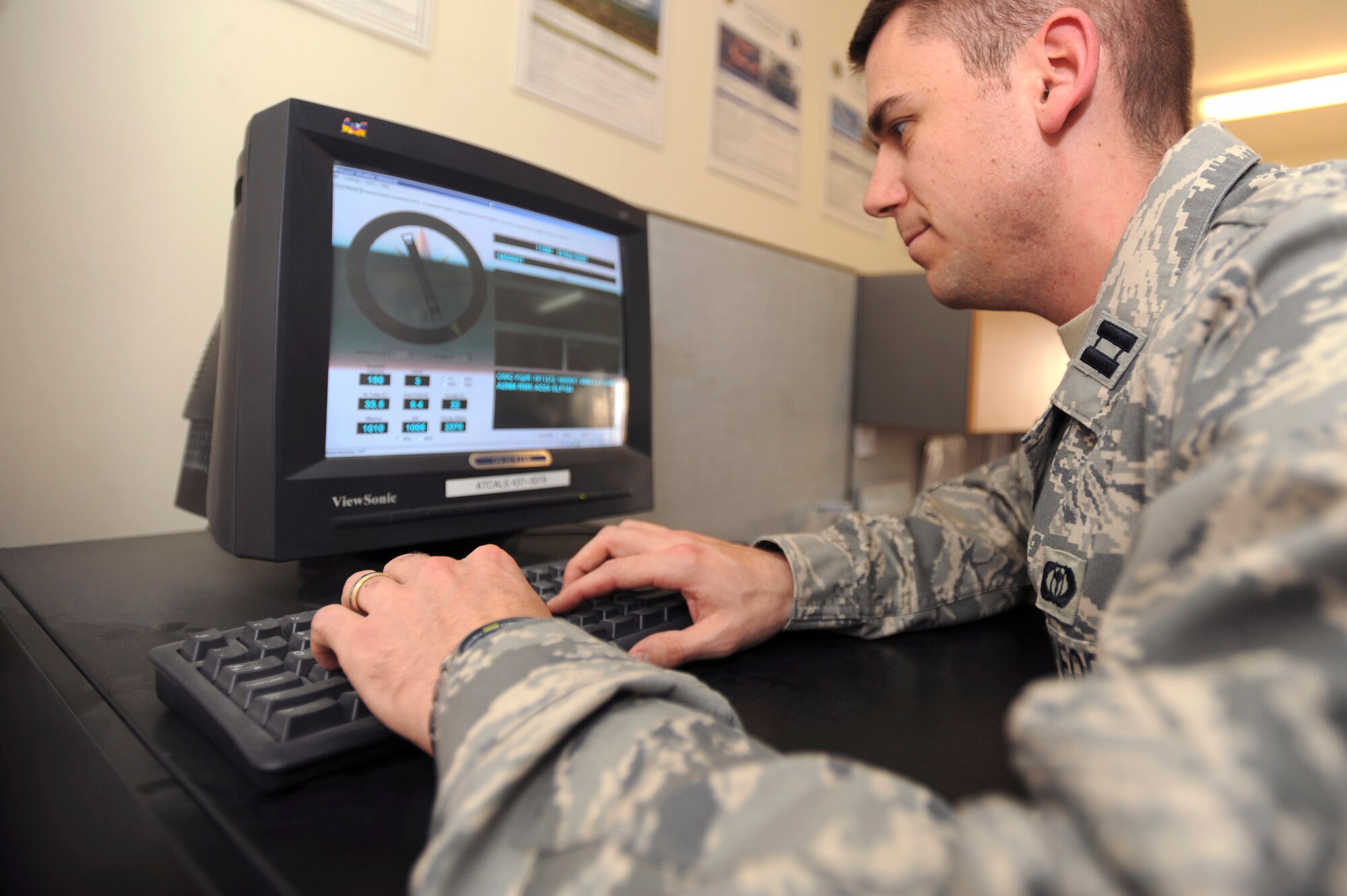 Capt. Jeffrey Cunningham checks readings from an FM-Q19 Airfield Sensor here March 19. Captain Cunningham is scheduled to teach a meteorology course next semester and while still completing his normal duties. The FM-Q19 is an in-place instrument for reading wind direction, temperature and humidity on the airfield. Captain Cunningham is the 379th Expeditionary Operation Support Squadron Weather Flight commander. (U.S. Air Force photo/Staff Sgt. Joshua Garcia)