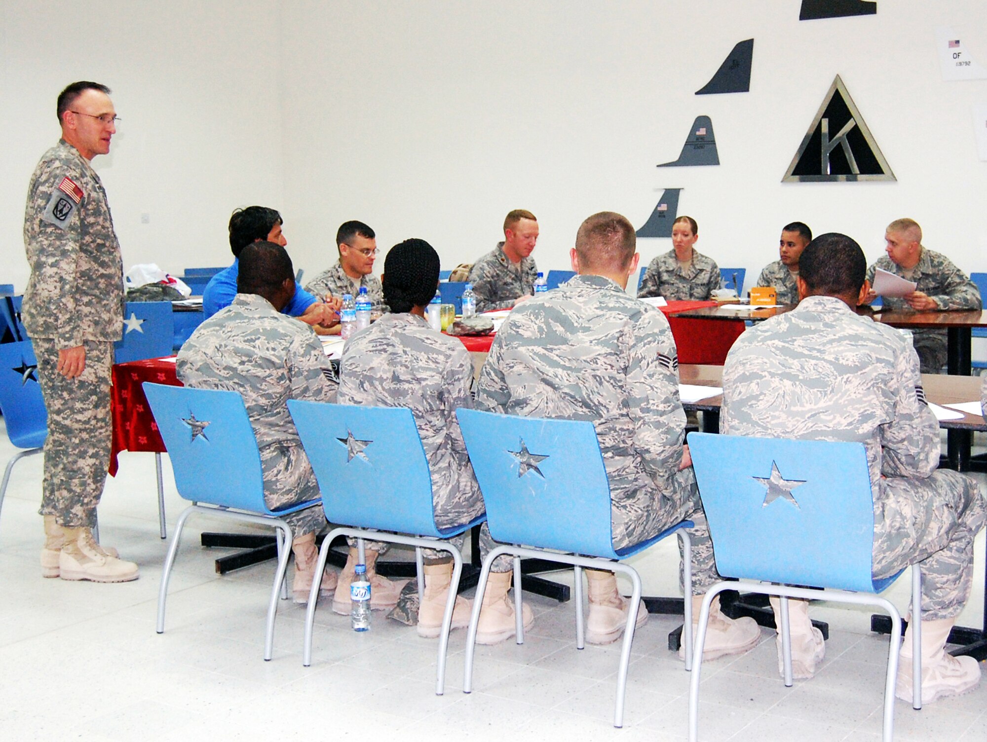 Army Maj. Jason Vranes talks to students in his marketing class Dec. 5. Students gave marketing presentations to a board comprised of Major Vranes, Col. John Lohr, 379th Expeditionary Mission Support Group commander, David Vela, 379th Force Support Squadron marketing director, and Maj. Rob Peacock, 71st Expeditionary Air Control Squadron. Major Vranes is a 2-43 Air Defense Artillery Battalion executive officer. (Courtesy photo)