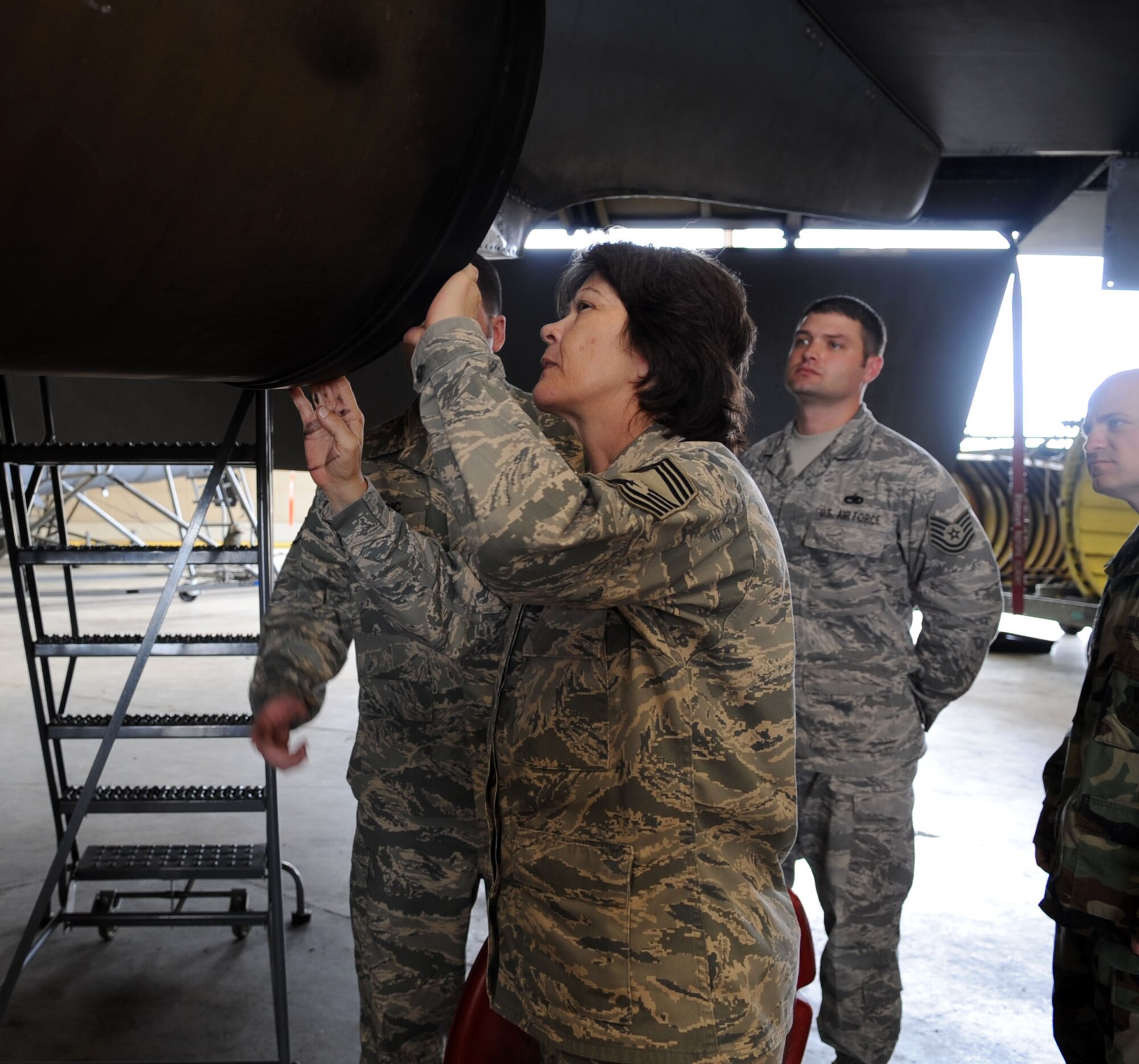 Chief Master Sgt. Carolyn Forester, 2d Maintenance Group quality assurance superintendent, along with other members of the 2d MXS perform preventative maintenance inspections on a de-paneled B-52 engine March 10. (U.S. photo by Airman 1st Class Brittany Y. Bateman)