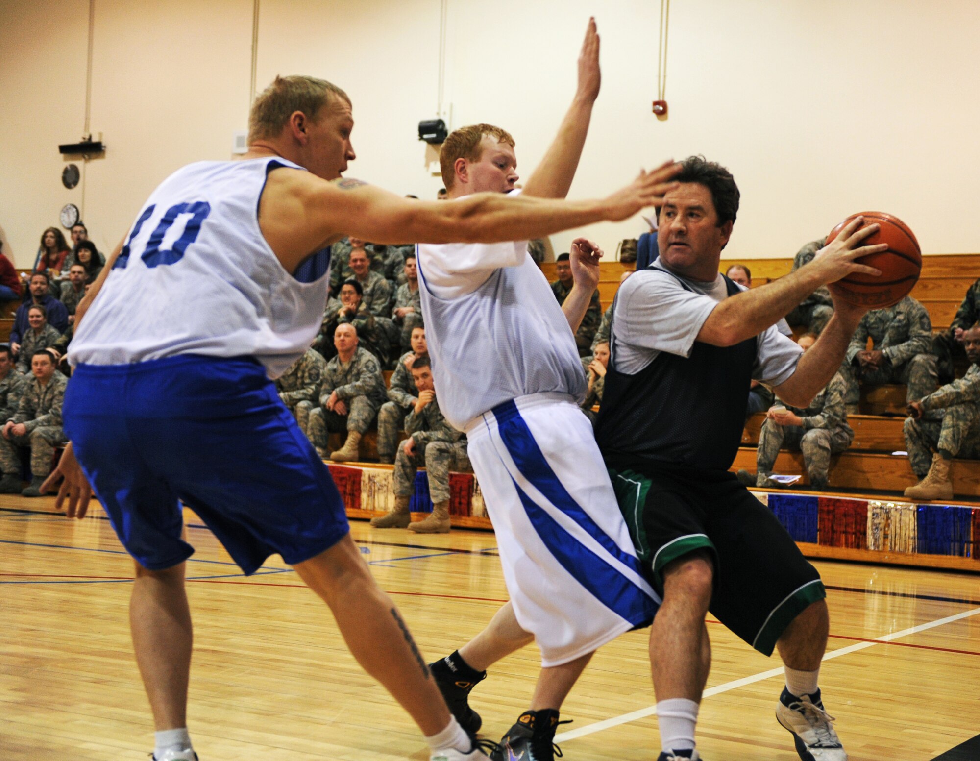 MOUNTAIN HOME AIR FORCE BASE, Idaho – Allen Niksich, over 30 all-star team, looks for an open teammate while being guarded by two opponents during the All Star Basketball Extravaganza at the Gunfighter Fitness Center March 20. The intramurals all-star team defeated the over 30 all-star team 61 to 43. (U.S. Air Force photo/Senior Airman Ryan Crane)