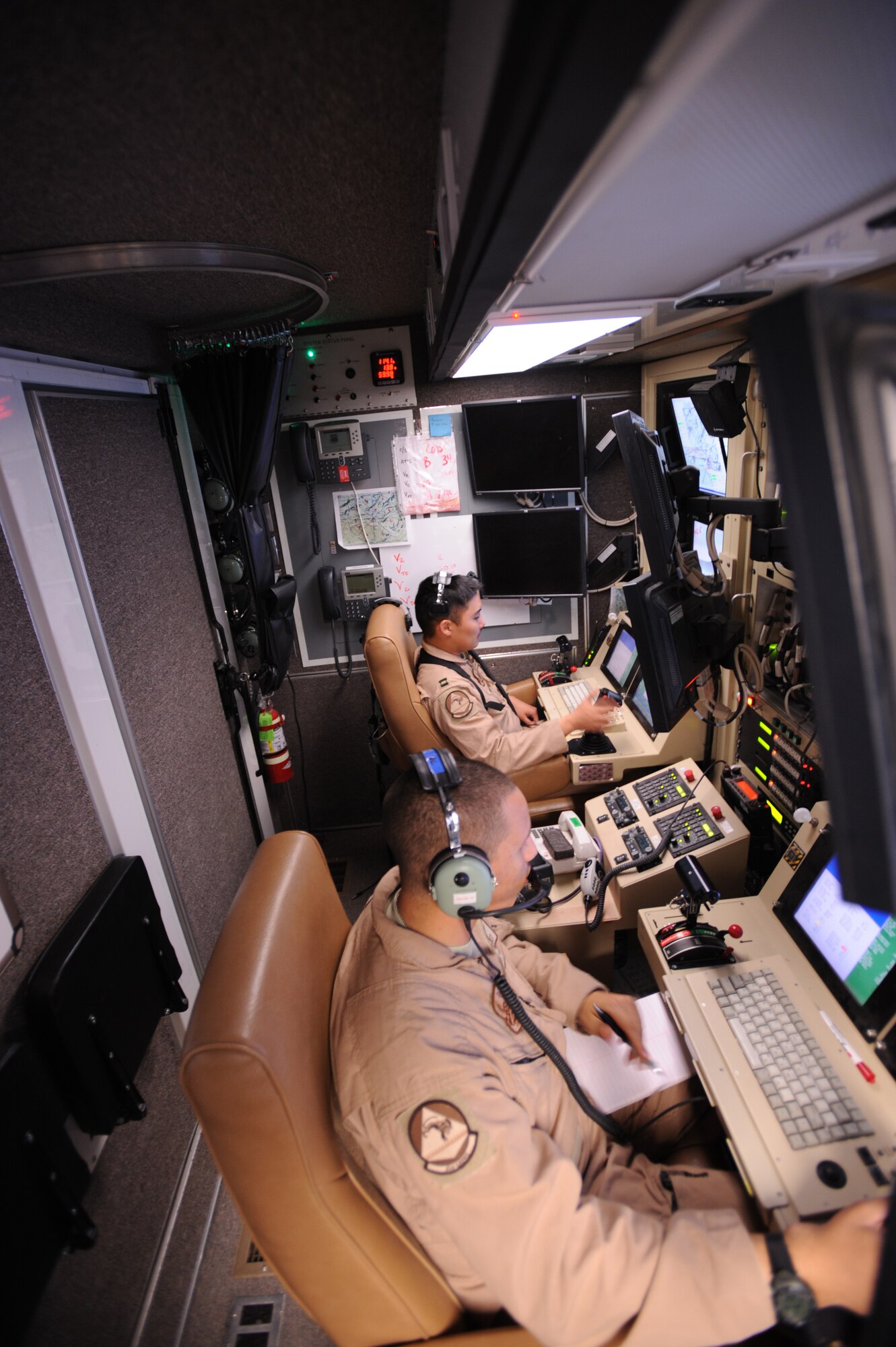 Capt. Ryan Jodoi, a UAV pilot, flies an MQ-9 Reaper while Airman 1st Class Patrick Snyder controls a full motion video camera at Kandahar Air Base, Afghanistan, March 13, 2009, in support of Operation Enduring Freedom.  (U.S. Air Force photo by Staff Sgt. James L. Harper Jr.)
