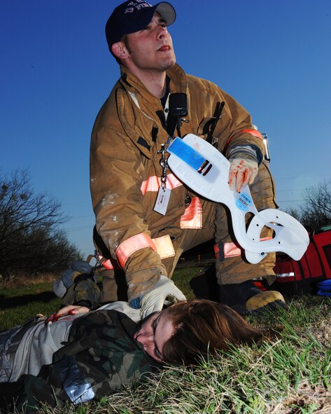 DYESS AIR FORCE BASE, Texas - Fireman Billy Morris, a civilian fire fighter here treats Airman First Class Nicole Kazimer during a base exercise here, March 3. The exercise is designed to prepare base personnel for a natural disaster such as a tornado strike on base housing.  (U.S. Air Force photo by Staff Sgt Alan Garrison)