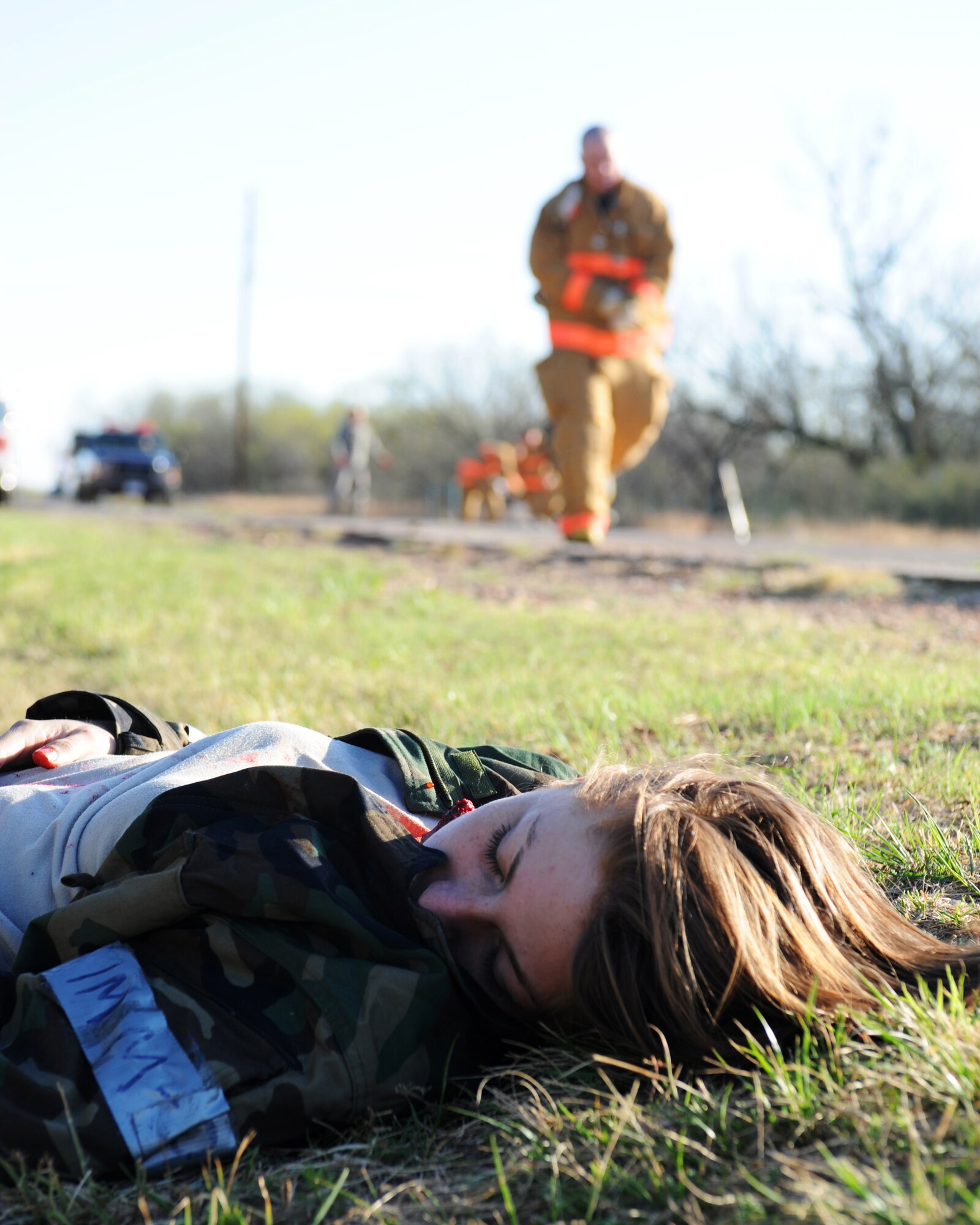 DYESS AIR FORCE BASE, Texas - A Dyess fire fighter runs to the aid of Airman First Class Nicole Kazimer during an exercise here, March 24.  The exercise is designed to prepare base personnel for a natural disaster such as a tornado strike on base housing.  (U.S. Air Force photo by Staff Sgt Alan Garrison) 