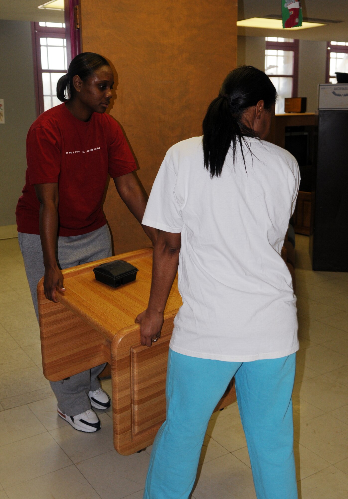 Tech. Sgt. Jamie Hunt, and Tech. Sgt. Latoya Hawkins, administrative assistant to the Chief of Staff of the Air Force, move furniture from a room to be painted during a painting project March 21 at Saint Elizabeth's Hospital, Washington. National Capital Region Airmen volunteered their weekend to help hospital staff members paint high-traffic areas used daily by patients and staff who are part of their treatment mall – the recovery program that patients attend Monday through Friday to prepare to return to the community. (U.S. Air Force Photo by Senior Airman Marleah Miller)