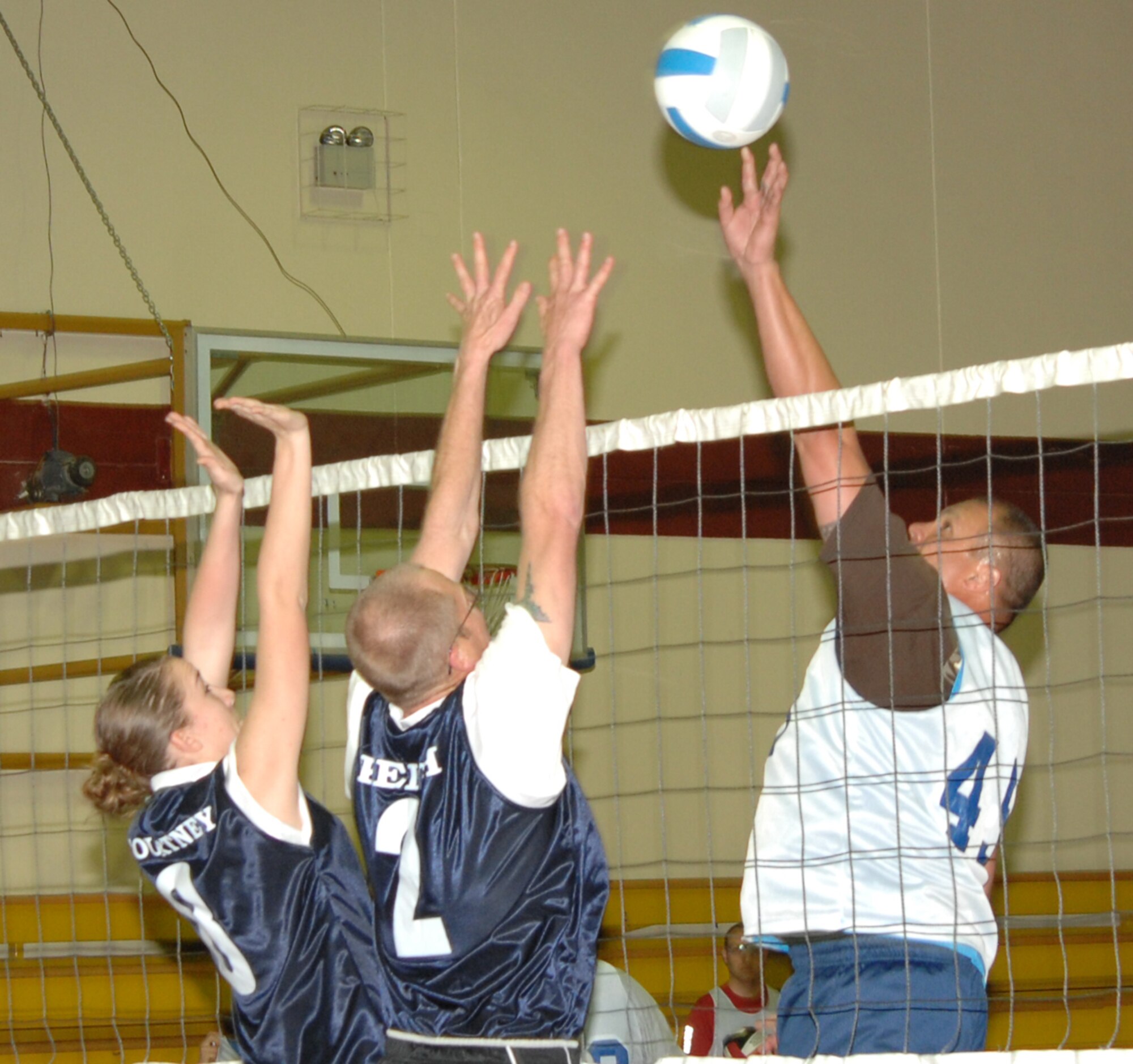 Donald Kane, member of the 39th Civil Engineer Squadron volleyball team spikes the ball towards a wall of Communications Squadron volleyball team defenders, during an intramural game at the Incirlik Fitness Center Monday, March 23, 2009. The intramural volleyball games are open to all squadrons on base and will culminate with a tournament at the end of the season to determine a champion.  (U.S. Air Force photo/Staff Sgt. Lauren Padden)