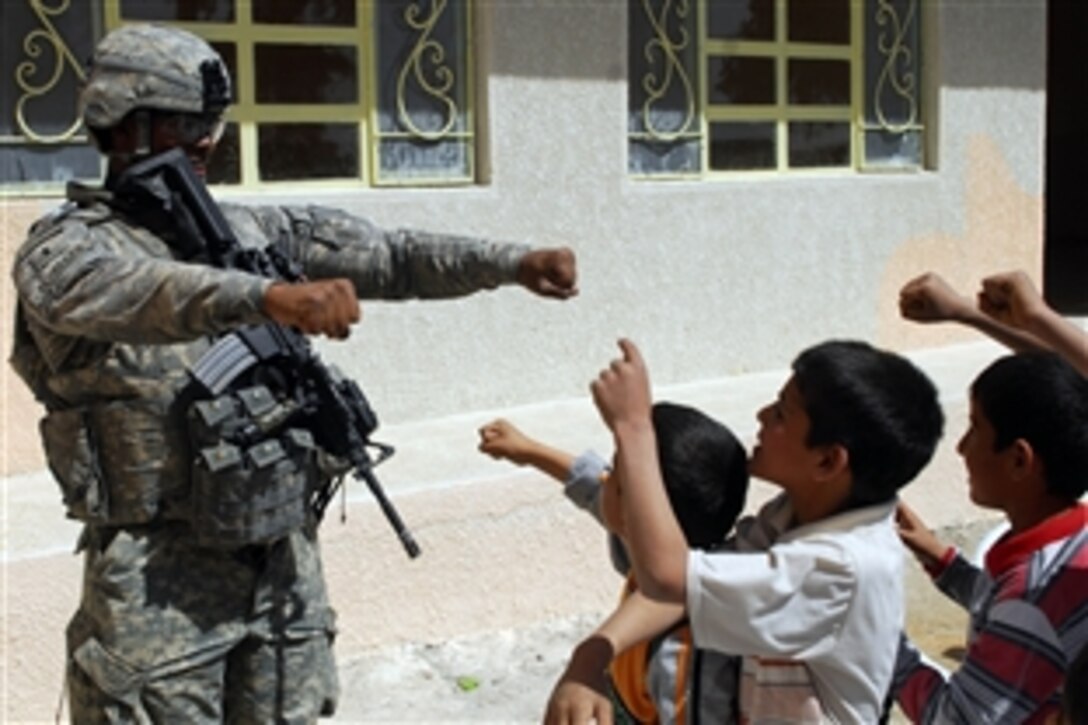 U.S. Army 1st. Lt. Chris Fluellen plays a game with students during the ribbon-cutting ceremony to celebrate the renovation of Al-Khaladeen School in Lutifiyah, Iraq, March 19, 2009. Fluellen is a platoon leader assigned to Company A, 1st Combined Arms Battalion, 63rd Armor Regiment. 