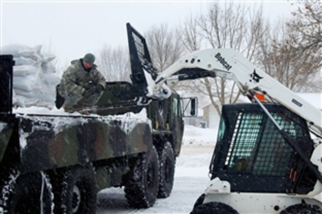 A North Dakota National Guard member gathers sandbags to stop the rising waters of the Missouri River and Apple Creek, March 24, 2009. The two bodies of water are covered with ice chunks and converging south of Bismarck, N.D., causing the water to overflow its banks. 