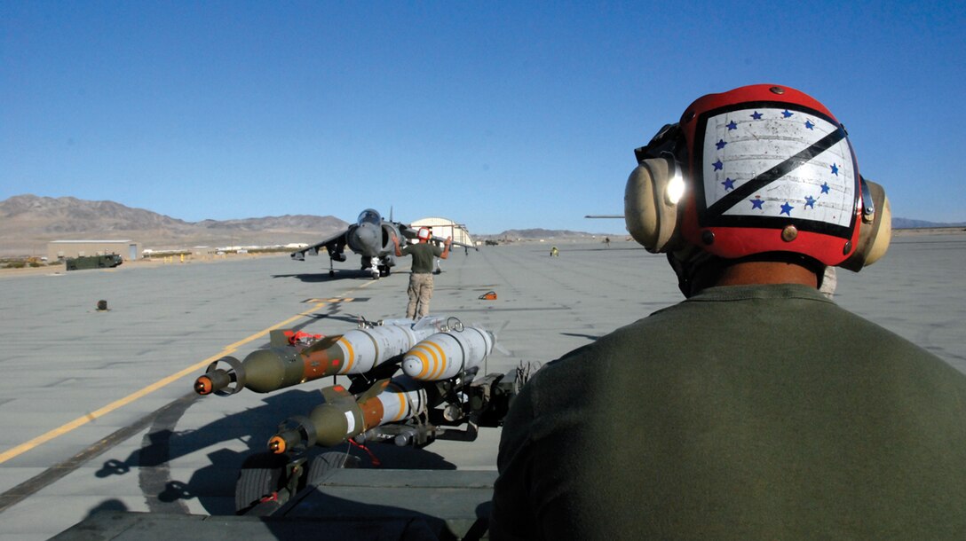 Pfc. Joseph Quiroz, Marine Attack Squadron 214 ordnance equipment operator, waits for an AV-8B Harrier to taxi, in order to load the jet with ordnance March 25 at the Strategic Expeditionary Landing Field in Twentynine Palms, Calif. Twenty-two Marines from VMA-214, based in Yuma, Ariz., participated in the training for their upcoming deployment to Afghanistan.