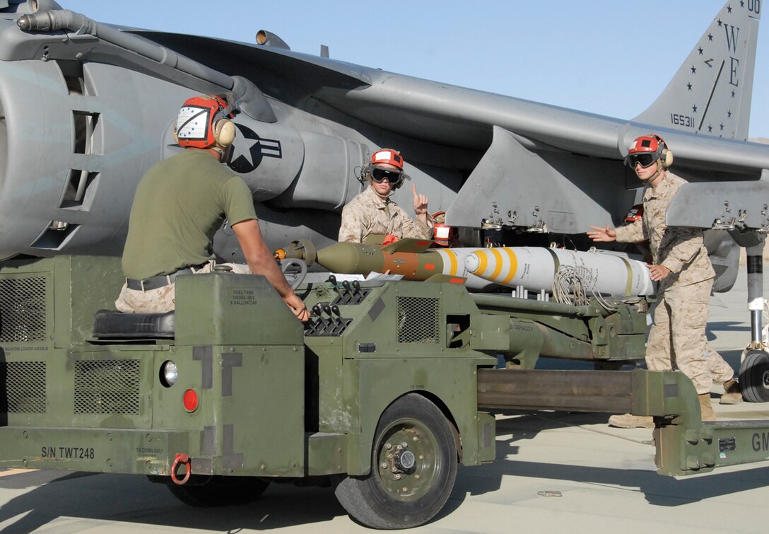 Marine Attack Squadron 214 Marines load a 500-pound bomb to an AV-8B Harrier at Strategic Expeditionary Landing Field here, March 25. Twenty-two VMA-214 Marines participated in the training, for their upcoming deployment to Afghanistan.