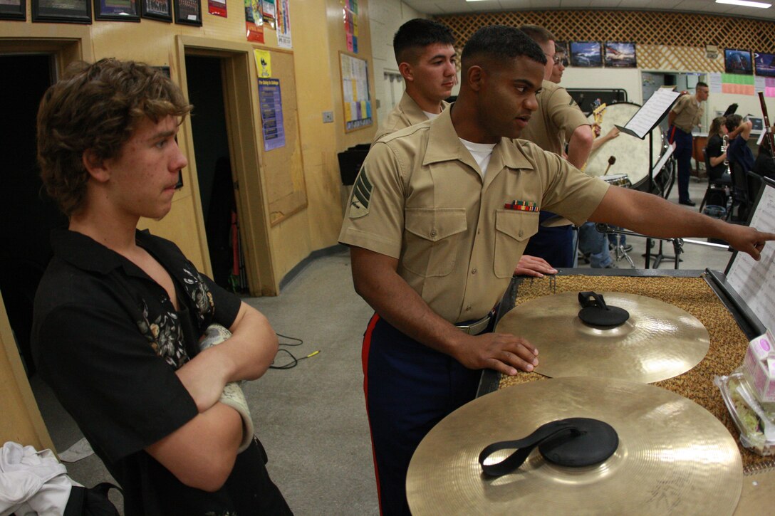 Sgt. Victor Diaz, a piano player with the Combat Center’s band, helps Andrew Miner, a Yucca Valley High School Yucca Valley, Calif., music student sharpen his music-reading skills. The band visits schools throughout the year to work with their music programs.