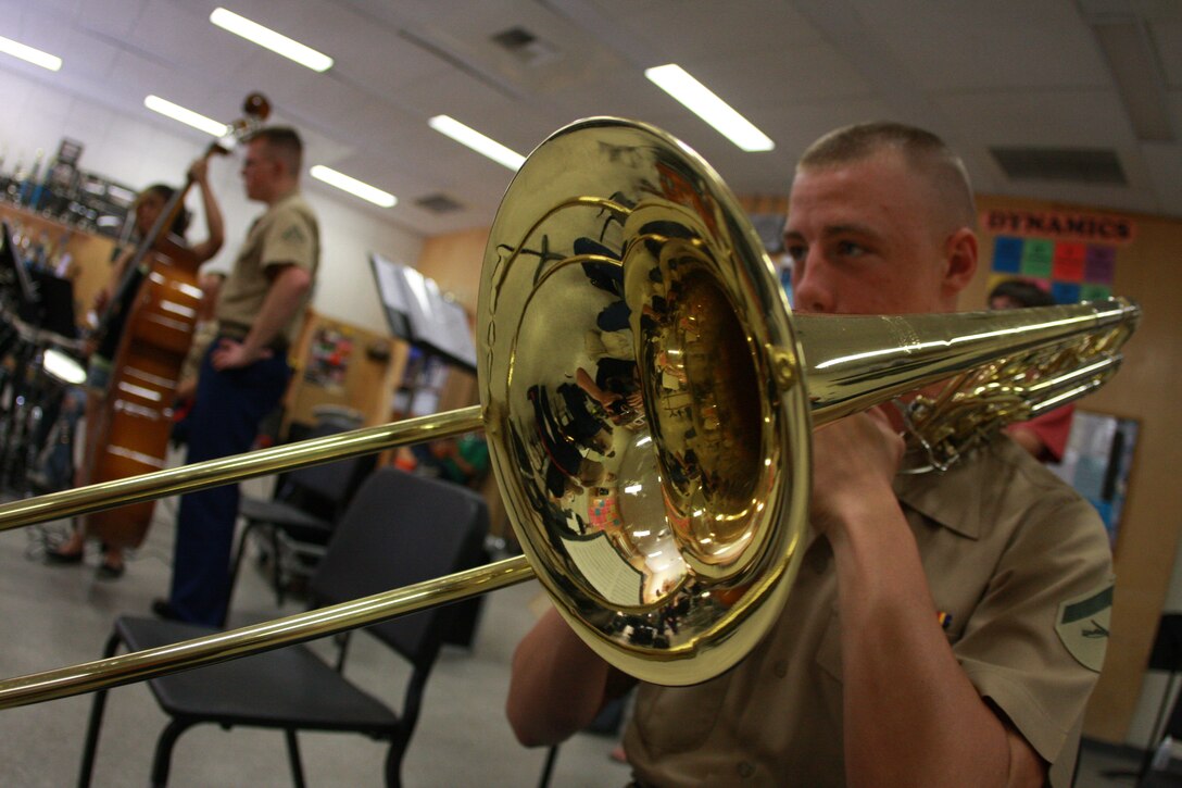 Lance Cpl. Chase Gilmore, a trombone player with the Combat Center band, plays a trombone from Yucca Valley High School, Yucca Valley, Calif.’s band program during a visit to the school to work with their music students.
