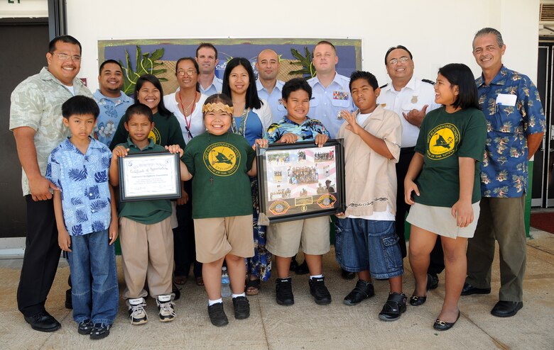 ANDERSEN AIR FORCE BASE, Guam - Representatives of Andersen's fire department pose for a picture with students and staff that participated in the Mar 14, 2009 Special Olympics Track and Field after a ceremony at Upi  Elementary Mar 23. The fire department in return gave the school a collage of photos, patches and a coin to remember their eventful day. (U.S. Air Force photo by Airman 1st Class Courtney Witt)