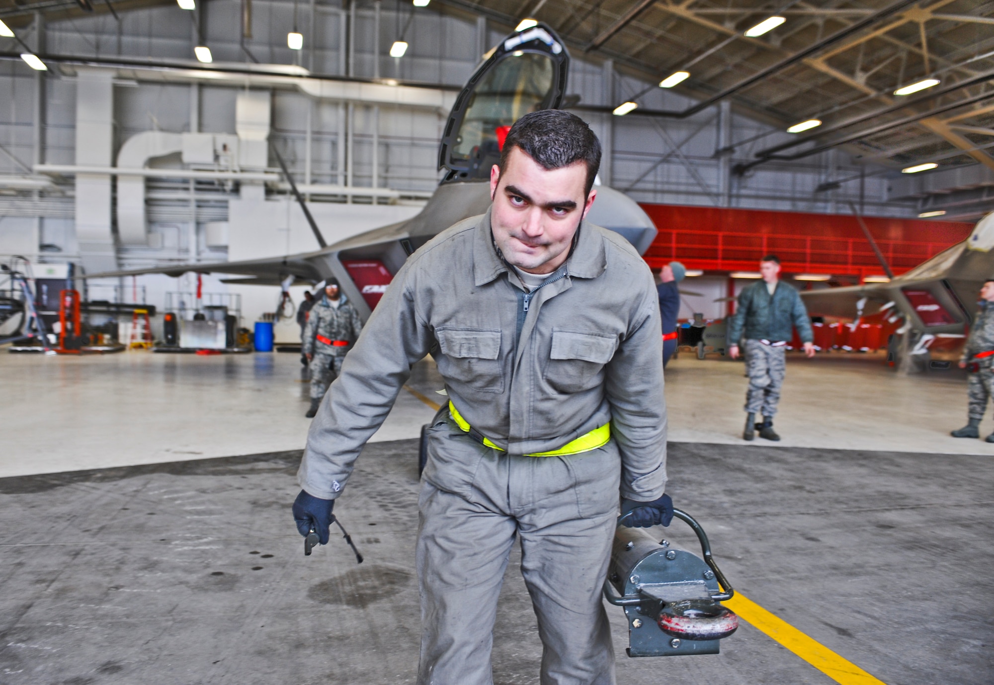 ELMENDORF AIR FORCE BASE, Alaska -- Tech. Sgt. Benjamin Waxenfelter, 525th Aircraft Maintenance Unit. unhooks an F-22 from a tow bar March 26, 2009. Raptors and maintenance equipment from the 525th Fighter Squadron are sheltered inside a hangar due to the ongoing eruptions of Mount Redoubt. (U.S. Air Force photo by Senior Airman Matthew Owens)